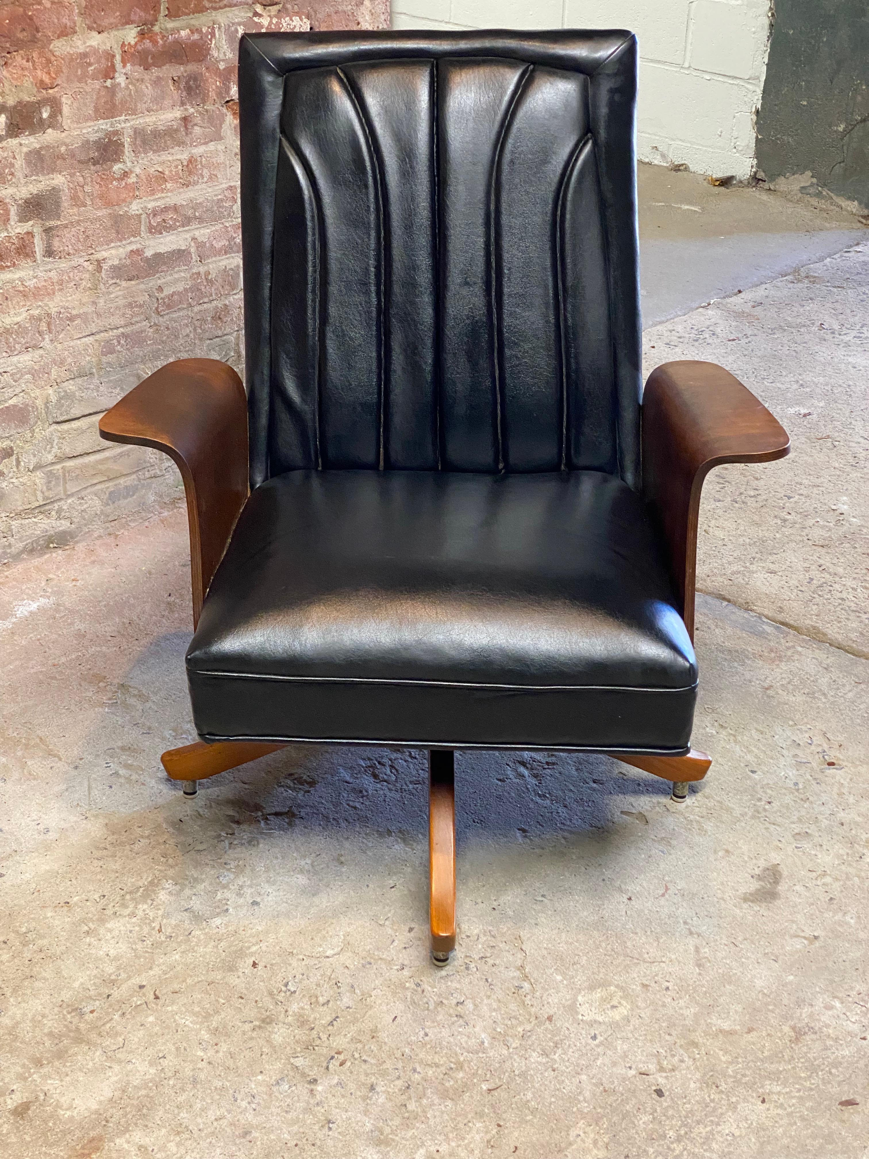 A nice black vinyl upholstered channeled back and walnut bentwood swivel lounge chair attributed to Miller Murphy, Inc. The chair swivels and has a relaxing little bounce action. Slightly curved and contoured wood legs. Comfortable and distinct.