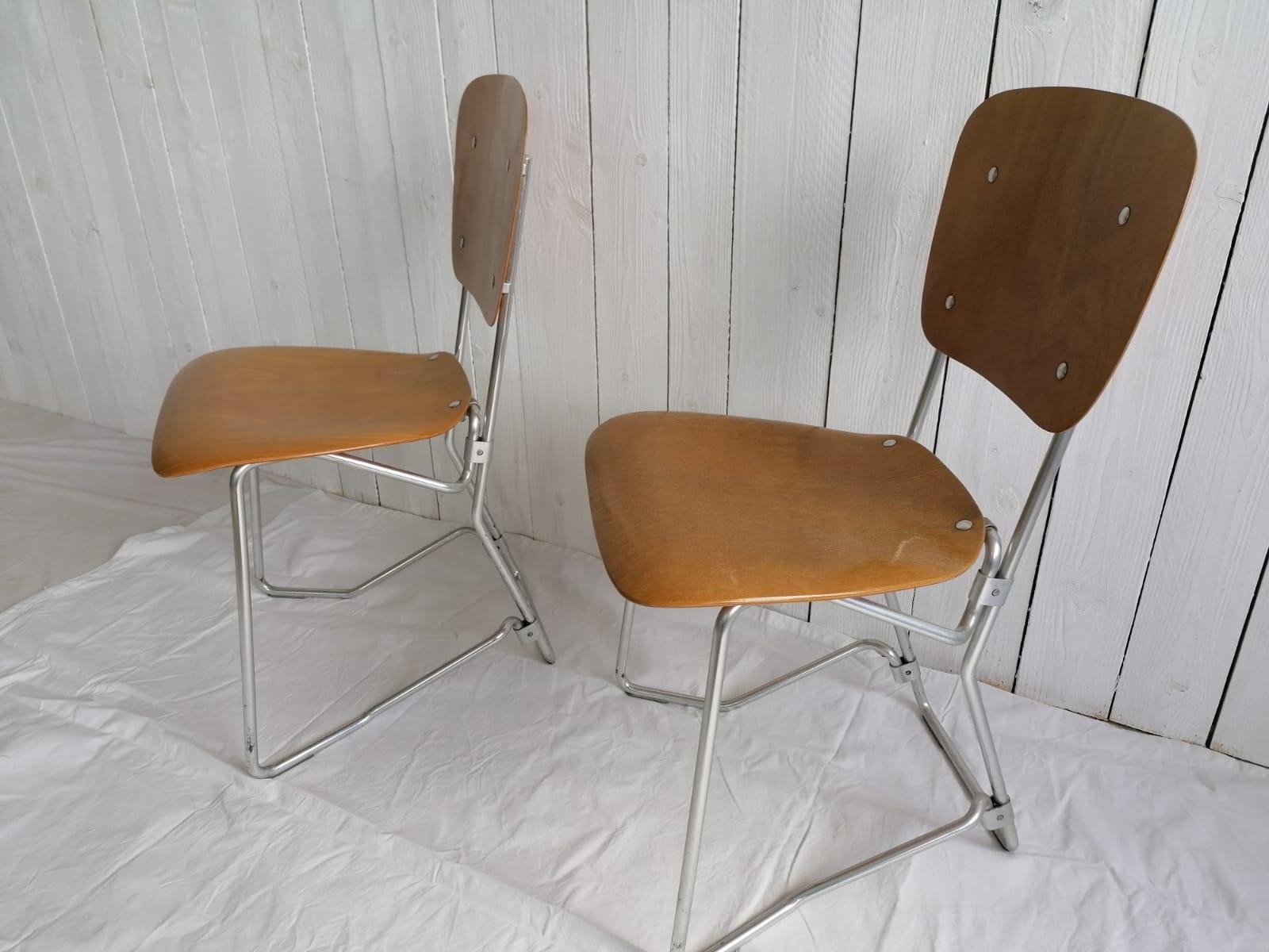 Folding chairs designed by Armin Wirth for Aluflex, 1951. Early production in the 1950s. Very nice patina to the beech lacquered wooden seats and backs. Very nice and clean condition, all marked with the Aluflex tag at the back. The chairs seats are
