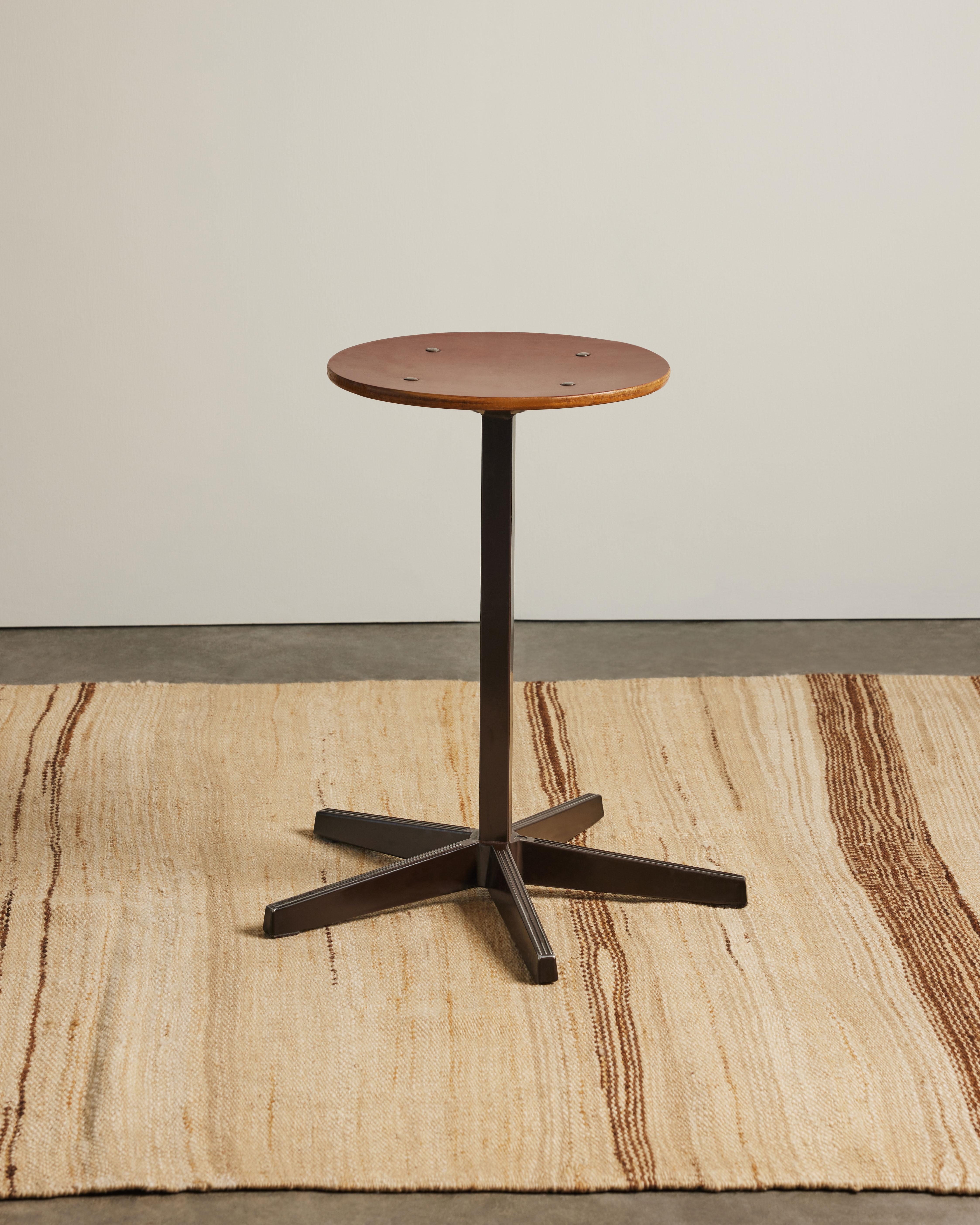 Un tabouret industriel avec un plateau en contreplaqué patiné, une quincaillerie apparente et une base en acier en forme d'étoile à cinq branches.
Une pièce d'accent distincte qui peut également être utilisée comme table d'appoint.
