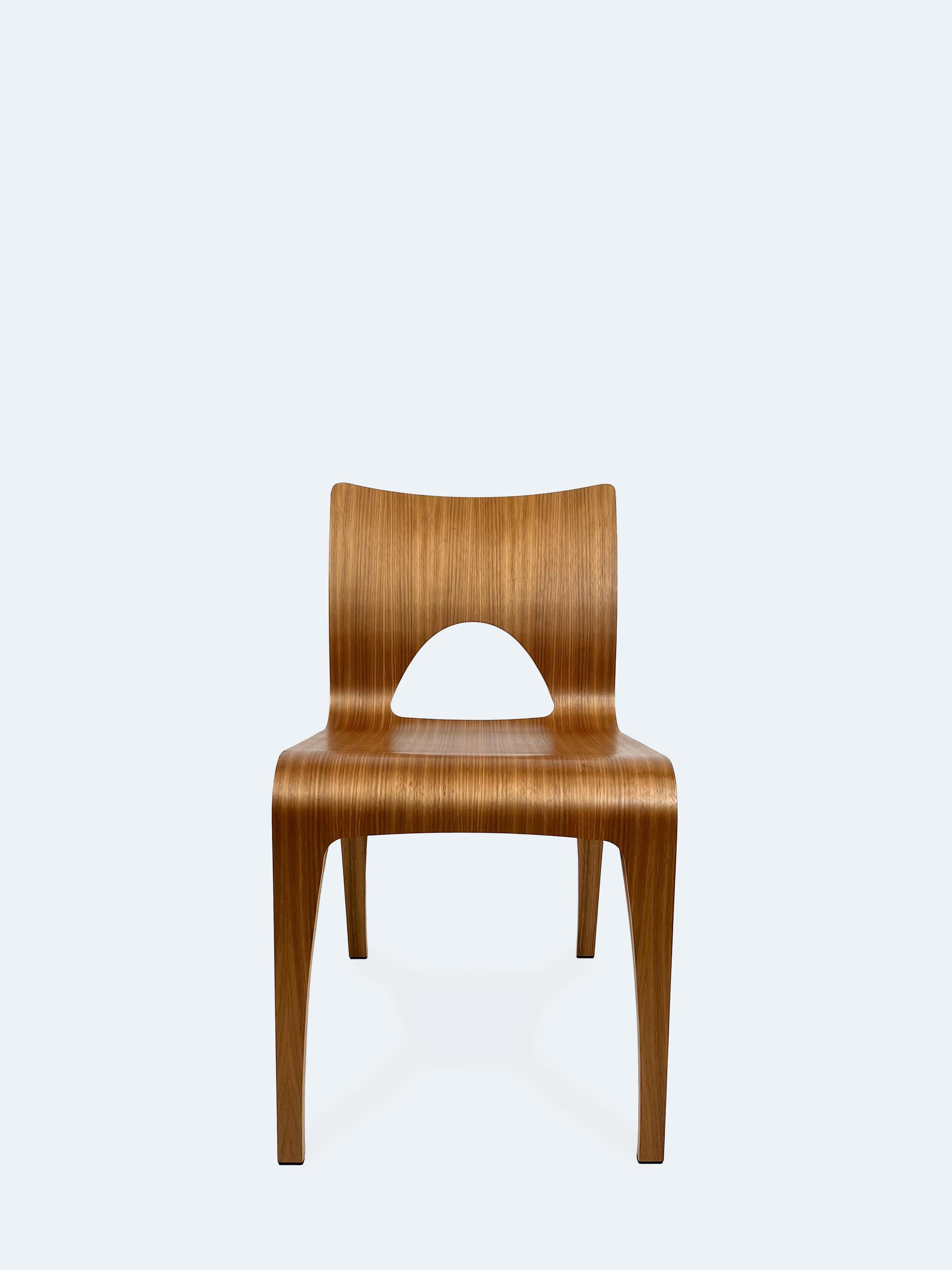 Der 2003 vom dänischen Hersteller DAN-FORM entworfene Kaarina Chair ist eine nahtlose Verschmelzung von skulpturaler Eleganz und technischer Präzision. Die fließende Silhouette des Stuhls aus Birkensperrholz mit warmem Walnussfurnier erweckt den