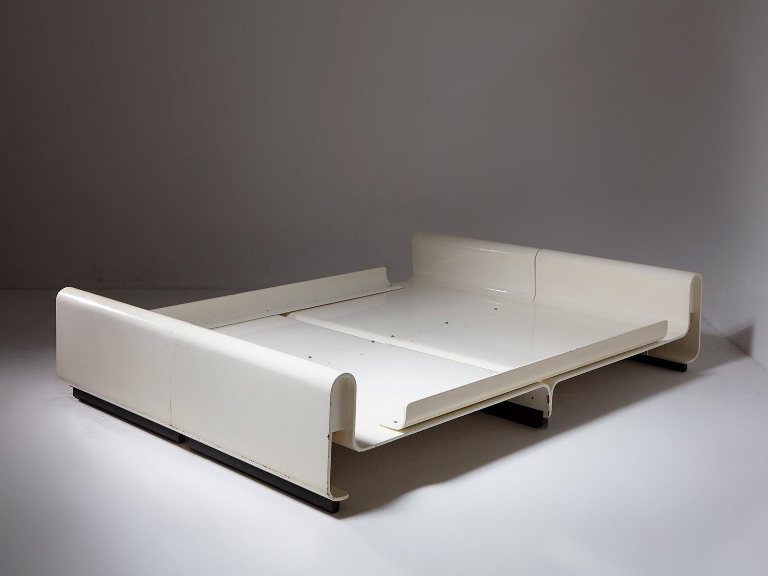 Large white double bed manufactured by Benatti.
Four twin plywood elements connected together with metal U shaped feet.
A visual homage to 30's plywood furniture production.