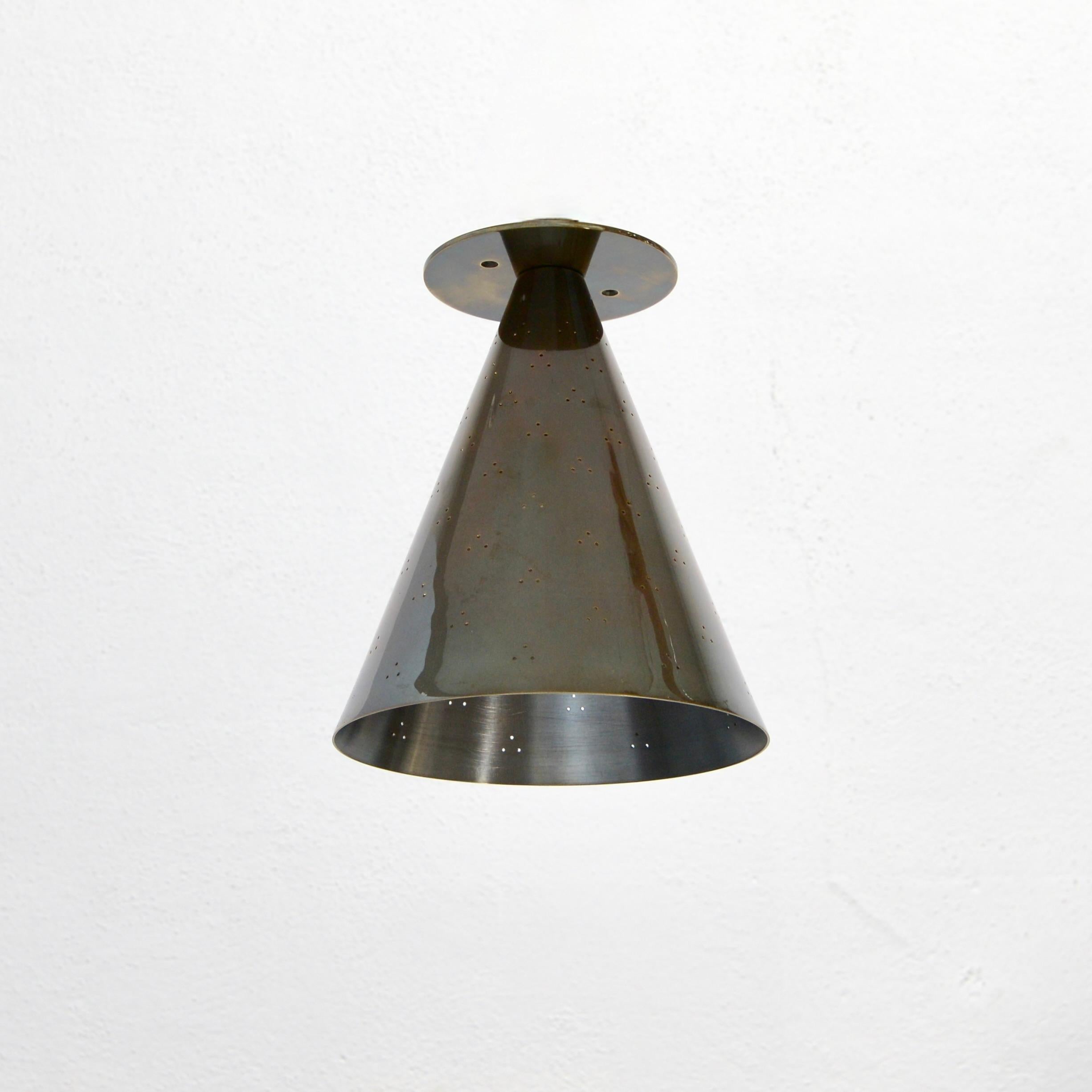 Part of Lumfardo Luminaries contemporary collection, the PMPT Flush Mount is a conical flush mount fixture in the spirit of Paavo Tynell of the Scandinavian Modern tradition. Made to order and crafted from sold perforated patinated brass, this
