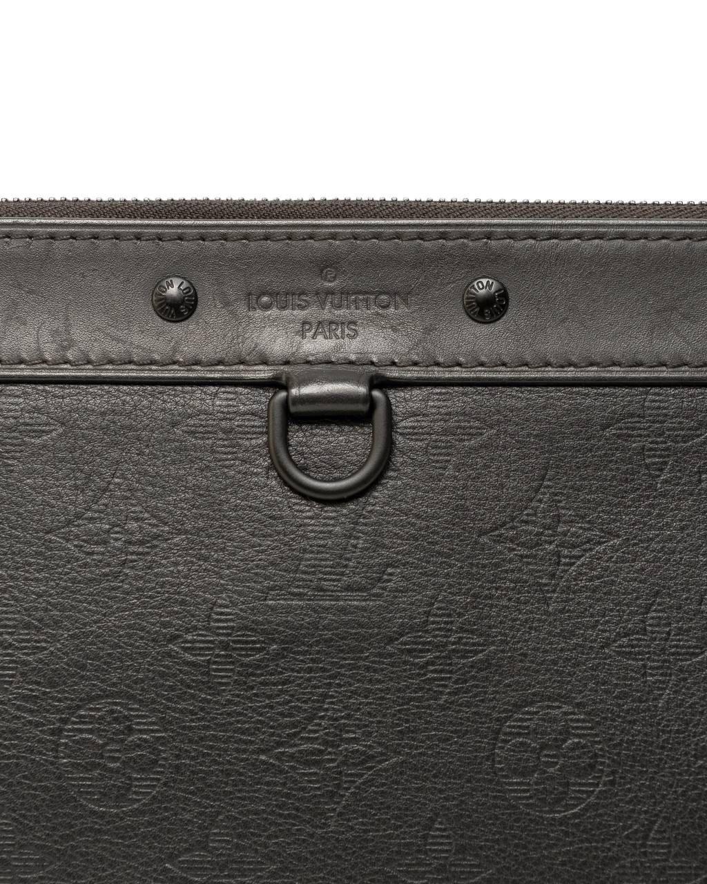 Pochette firmata Louis Vuitton, modello Discovery, realizzata in pelle empreinte nera con hardware tono su tono. Dotata di una chiusura superiore a zip, internamente rivestita in tela nera, abbastanza capiente. L'articolo si presenta in ottime