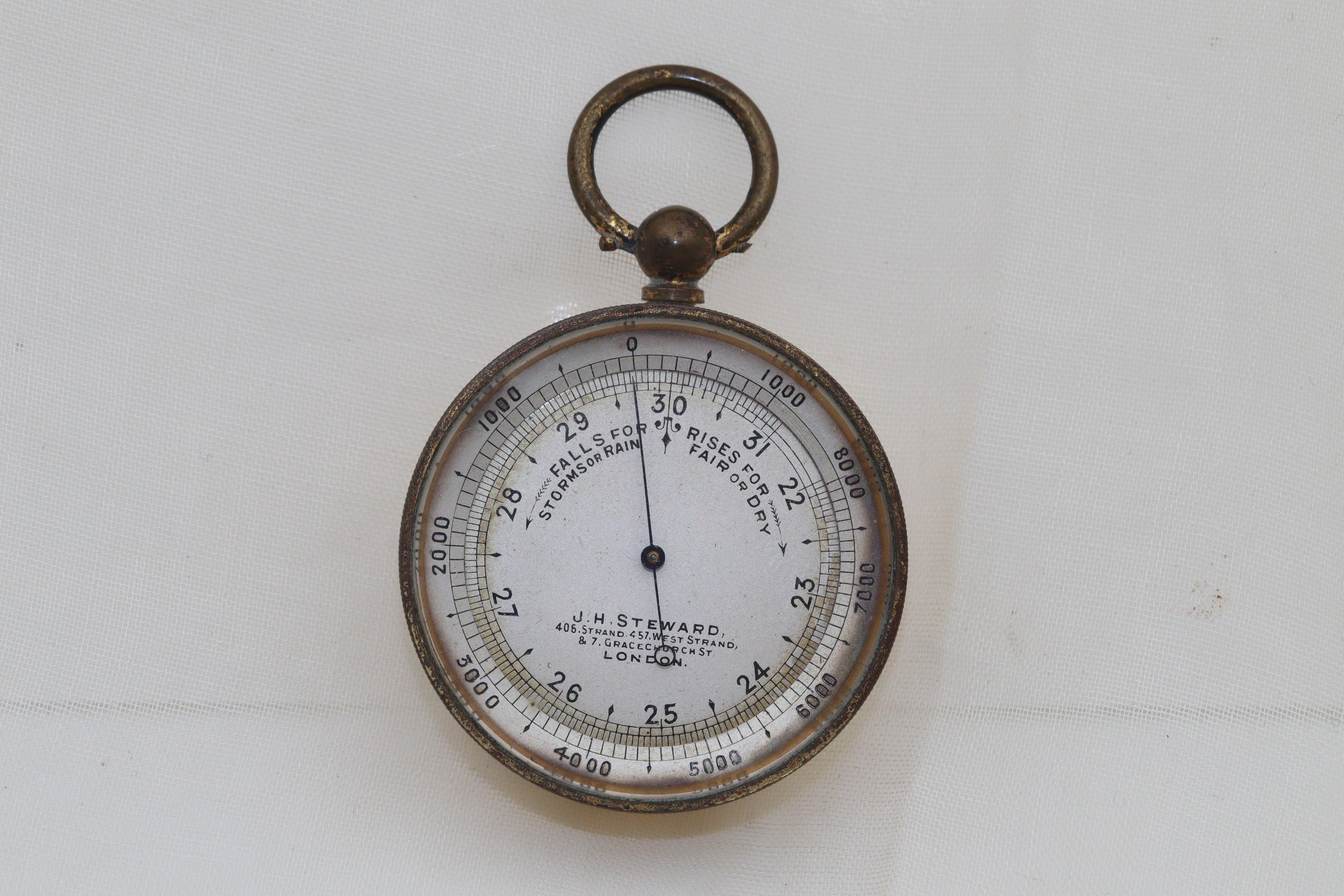 Dieses Taschenbarometer wurde von der Firma J. H. Steward hergestellt und befindet sich noch immer in seinem originalen lederbezogenen Etui. Das versilberte Zifferblatt mit dem gebläuten Zeiger ist von einer drehbaren Höhenmesserlünette umgeben, auf