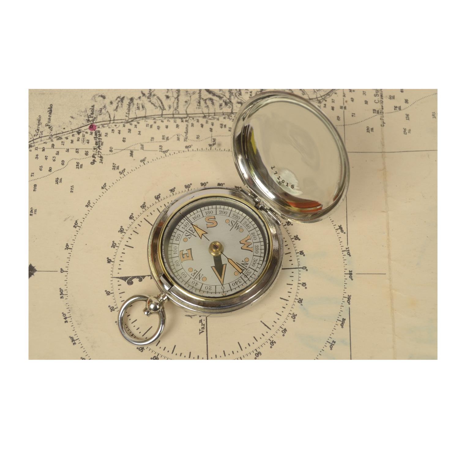 Pocket compass used by British aviation officers made of chromed brass in the shape of a pocket watch, complete with chain signed Dennison Birmingham VI 59259 of 1917. The compass has a lid with snap closure with release button inside of the ring.