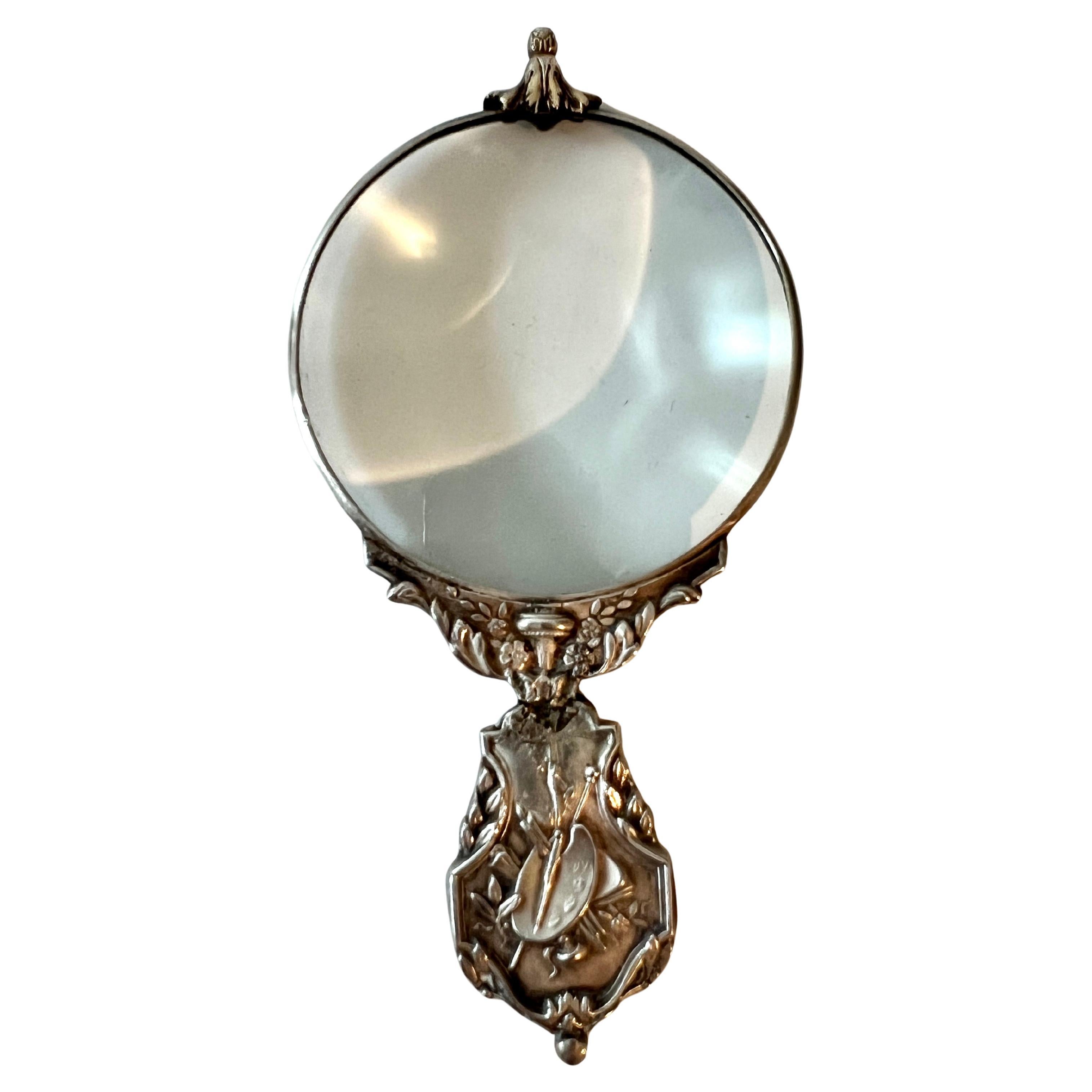 A beautiful Sterling Pocket Magnifying glass with finial detail atop and painter detail handle  The piece is from the Charles Mayer Company and is in its original leather box.  

A complement to any pocket or purse to see the fine details.  A very