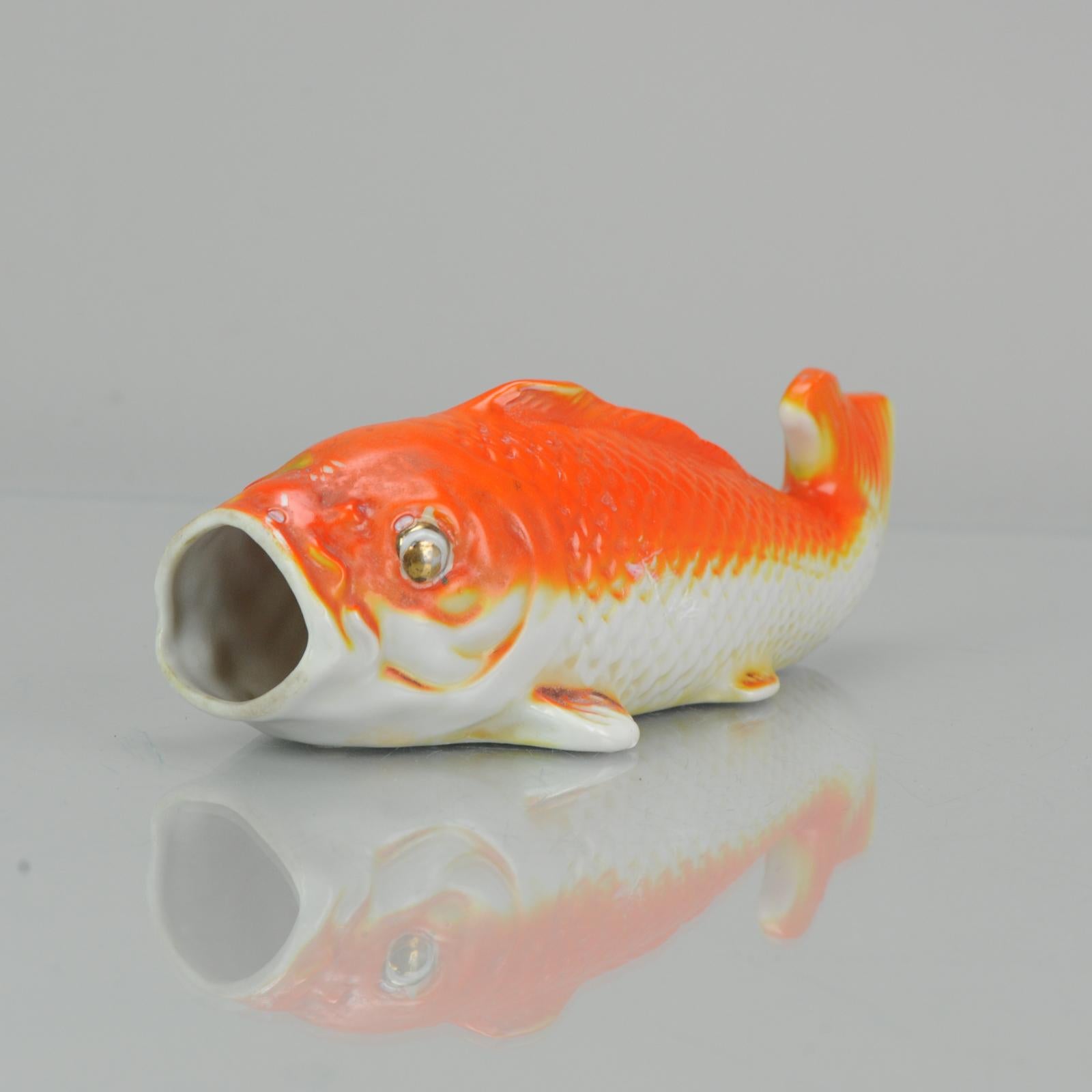 A very nice wall pocket vase in the shape of a Koi Carp.

The wall vase has been manufactured from fine porcelain and hand painted in vibrant shades of orange, white and black. The exterior surfaces have a raised relief design. There is a small