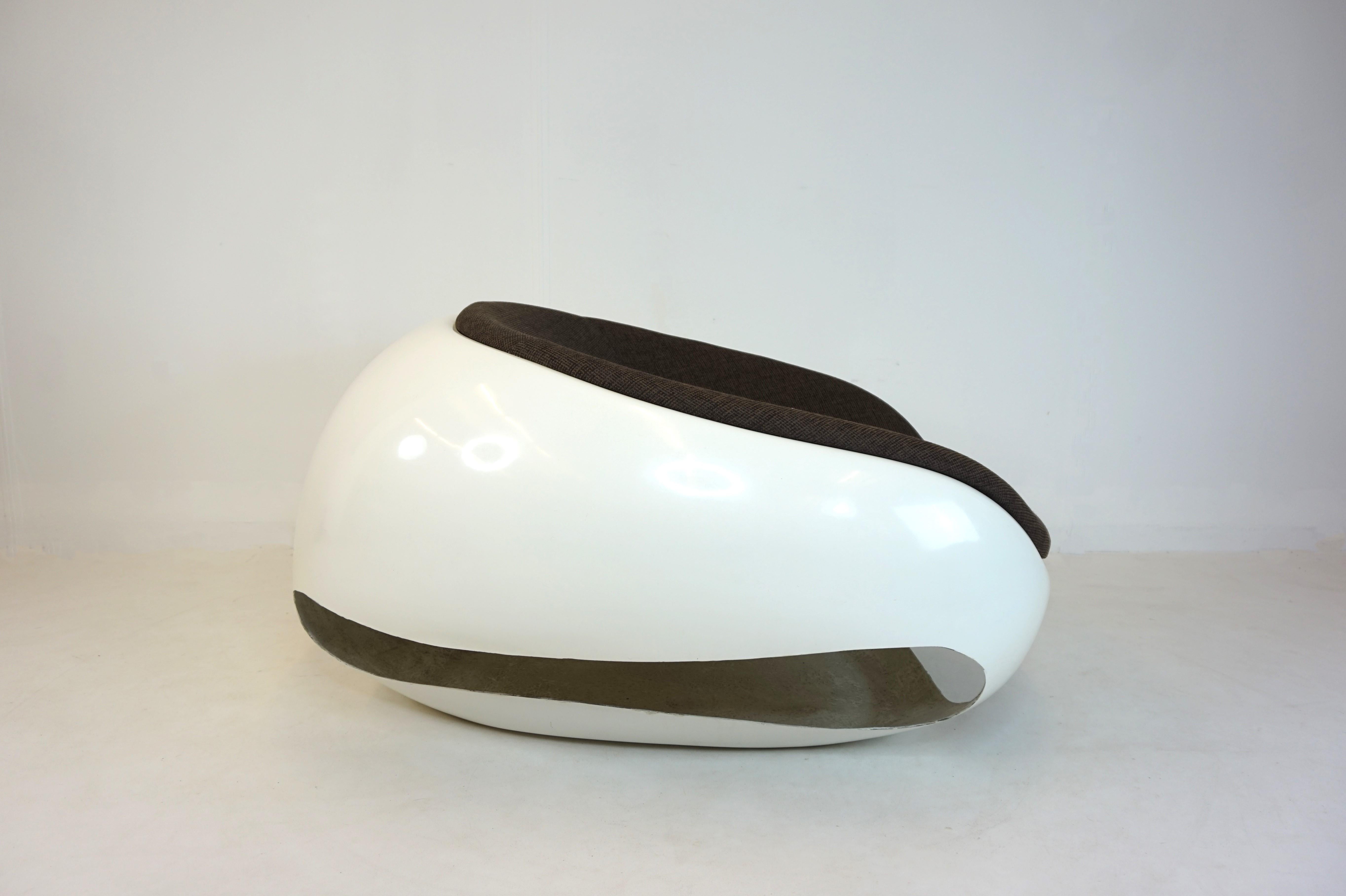 Designed in an organic shape, this space age armchair is in excellent condition. The white fiberglass shell shows minimal signs of wear, as does the brown mottled cotton fabric of the seat shell. This hard to find chair offers a fantastic seating