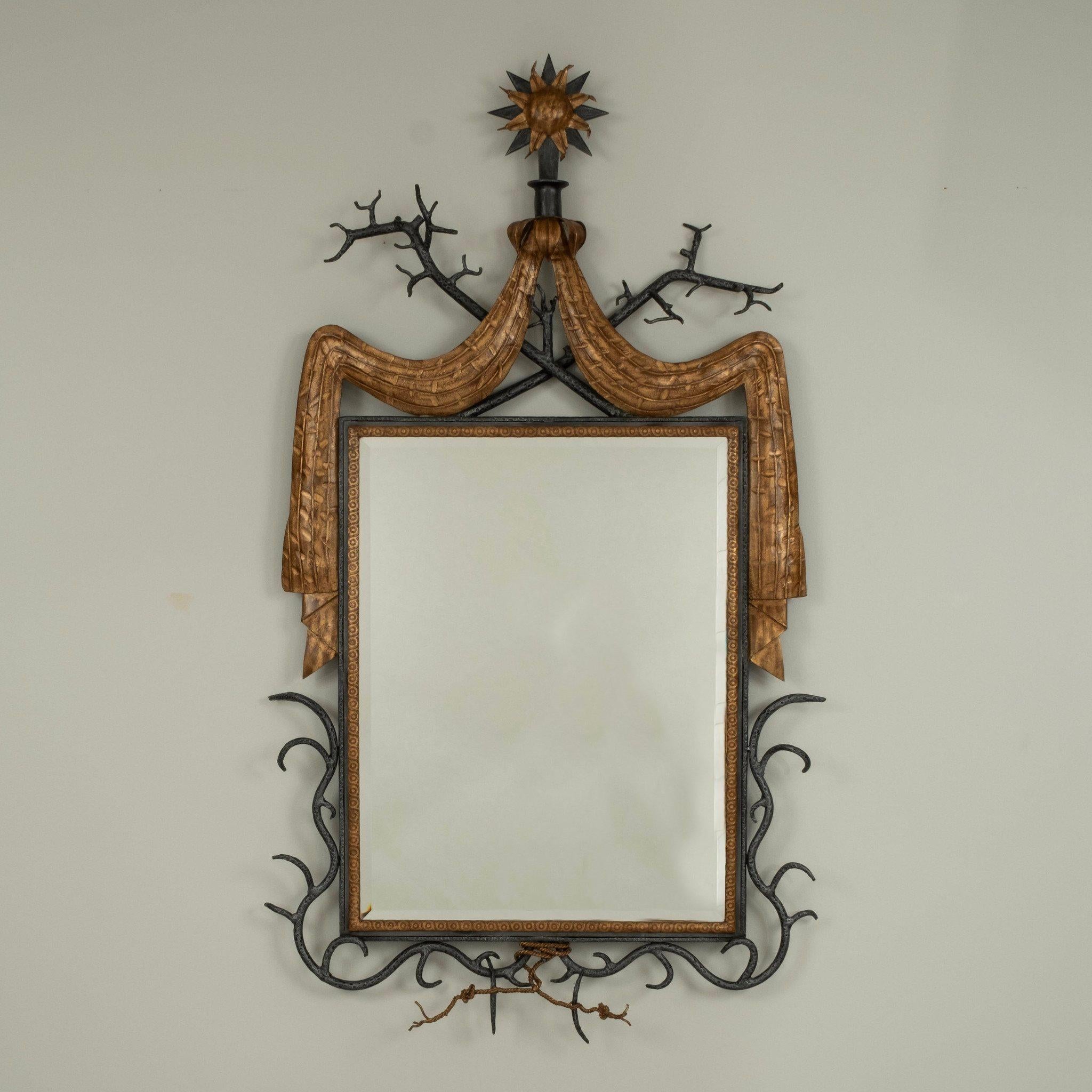Beautiful French 1940s Poillerat style wrought iron and gold trimmed wall mirror with sun, branch, twig and swag detail.