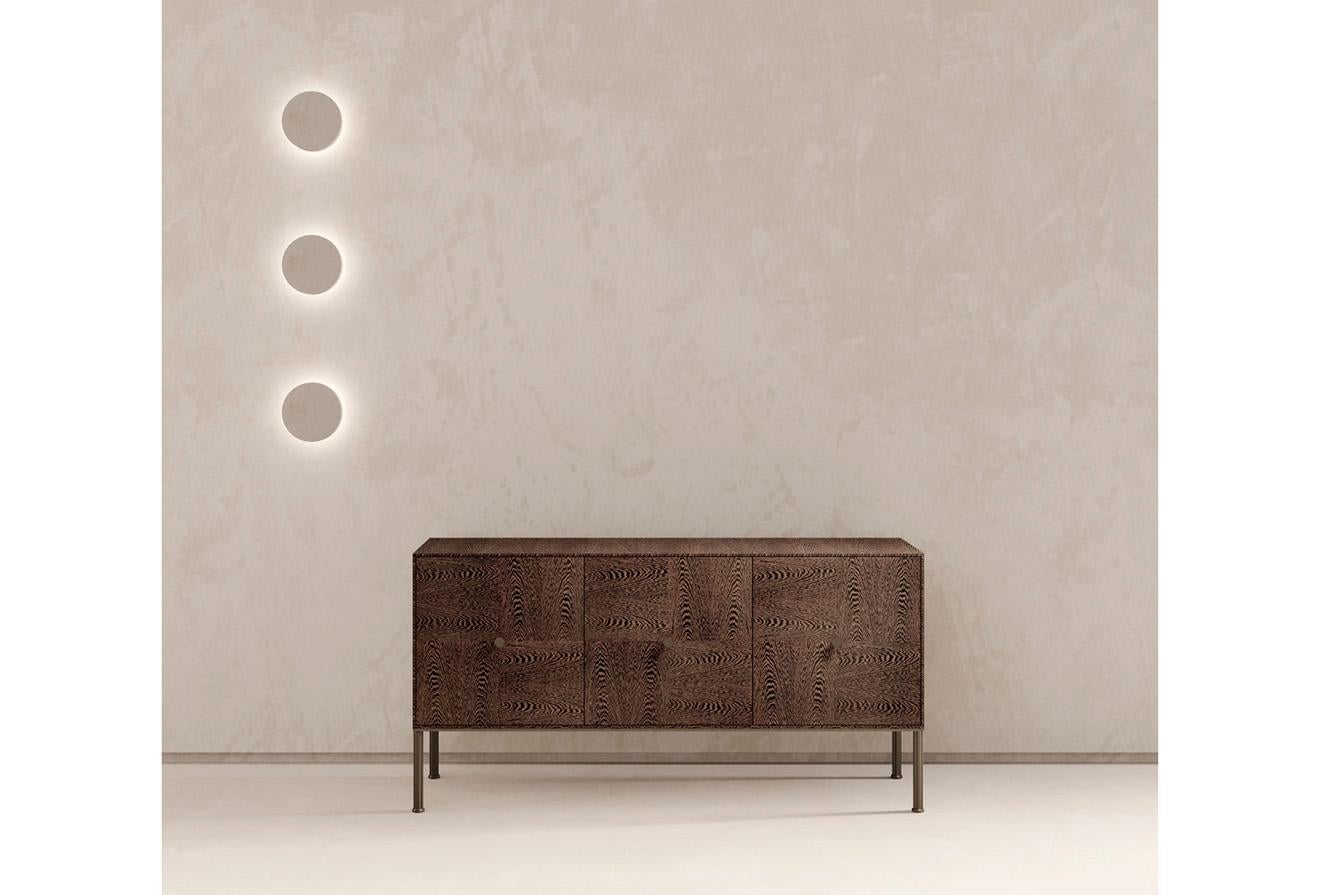 Point is a modern sideboard of geometric lines. Precious inlays handcrafted. A metal handle of architectural value conceived as a focal point. As shown in Wengè veneer, inside lacquer Cardinal matt, metal finish Bronze Selenio. Made in Italy.