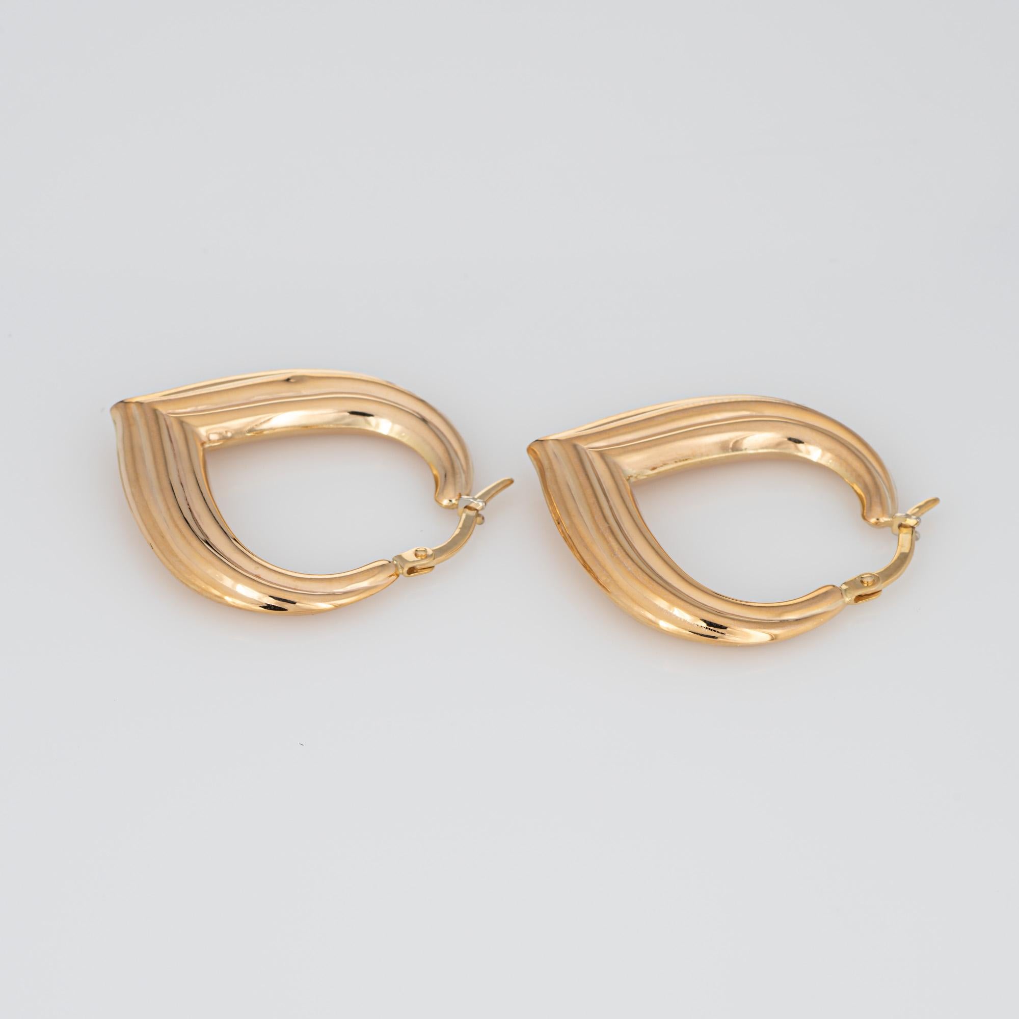 Fine detailed pair of pointed oval hoop earrings crafted in 14k yellow gold (circa 1980s). 

The stylish earrings feature a ridged design terminating to a pointed design. The hollow earrings offer a lightweight feel for a comfortable fit on the