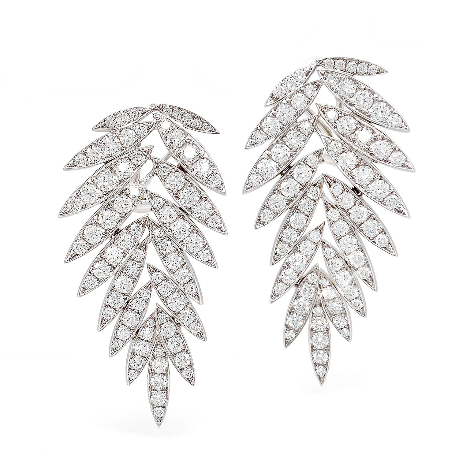 These diamond drop earrings feature round brilliant cuts in leaf shaped 18k white gold settings that fan out. The earrings fasten with clip-backs and measure 0.97 inches (width) by 1.92 inches (length) by 0.15 inches (depth).
