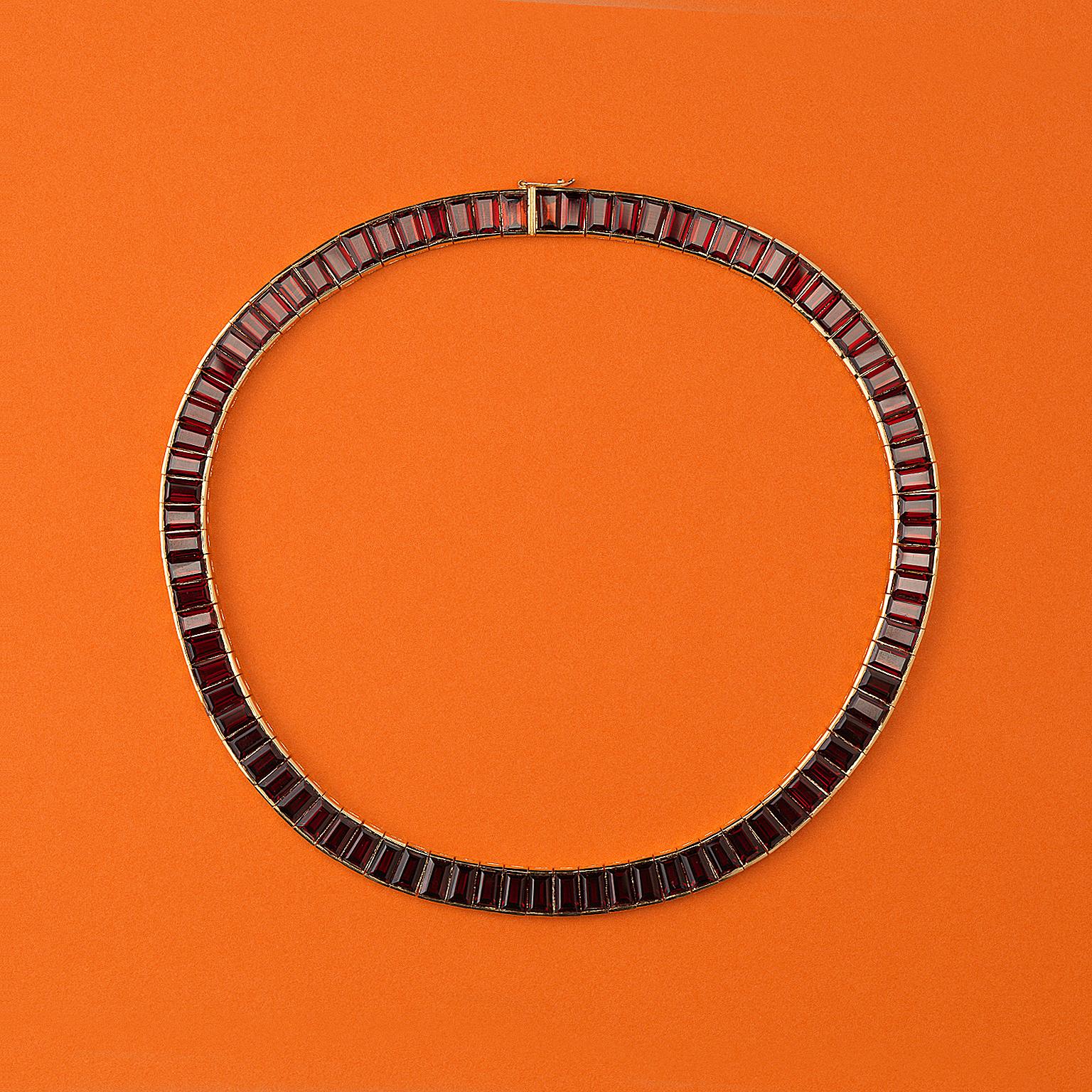 Collier aus 18 Karat Gold mit 79 spitz zulaufenden Granaten im Baguetteschliff und Pavé-Fassung, signiert und nummeriert: Poiray, 23978, Frankreich, um 1985.

gewicht: 99,21 Gramm
länge: 45 cm
breite: ca. 9 mm