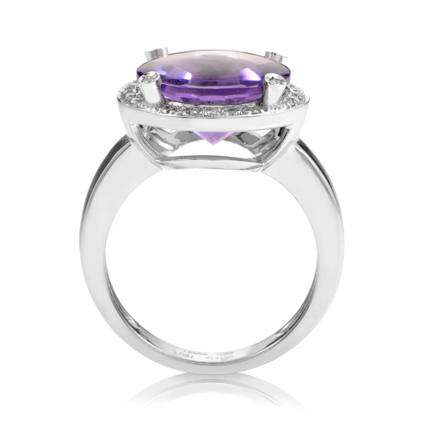 The regal elegance of this Poiray ring is mesmerizing. The ring is made of 18K white gold with a round cut faceted amethyst totaling ~5ct that is beautifully held by four diamond set prongs which rise from a halo of pave set diamonds totaling