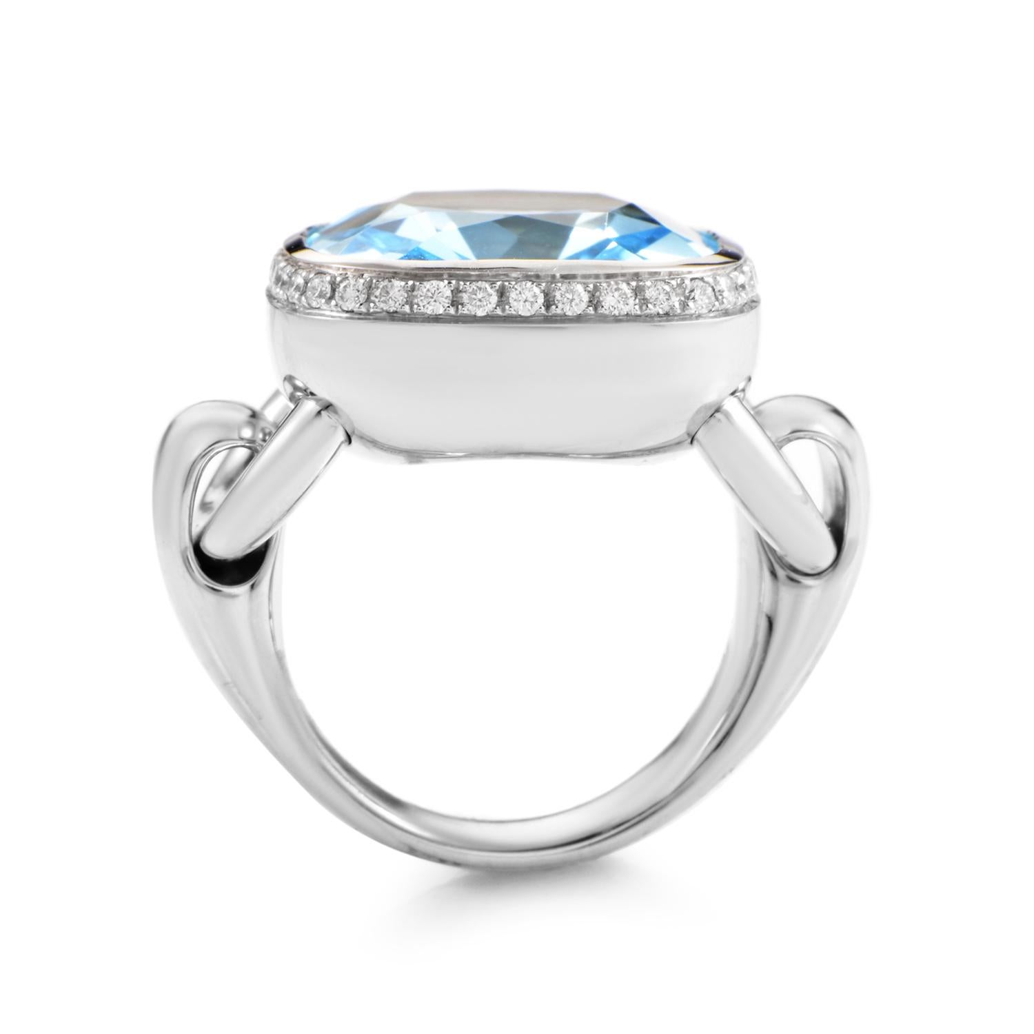 This extravagant Poiray ring is overwhelmingly glamorous. The ring is made of 18K white gold that is specially designed with hinges for a smooth, movable, cushion shaped bezel setting. A faceted ice blue topaz totaling a generous ~12.45ct is