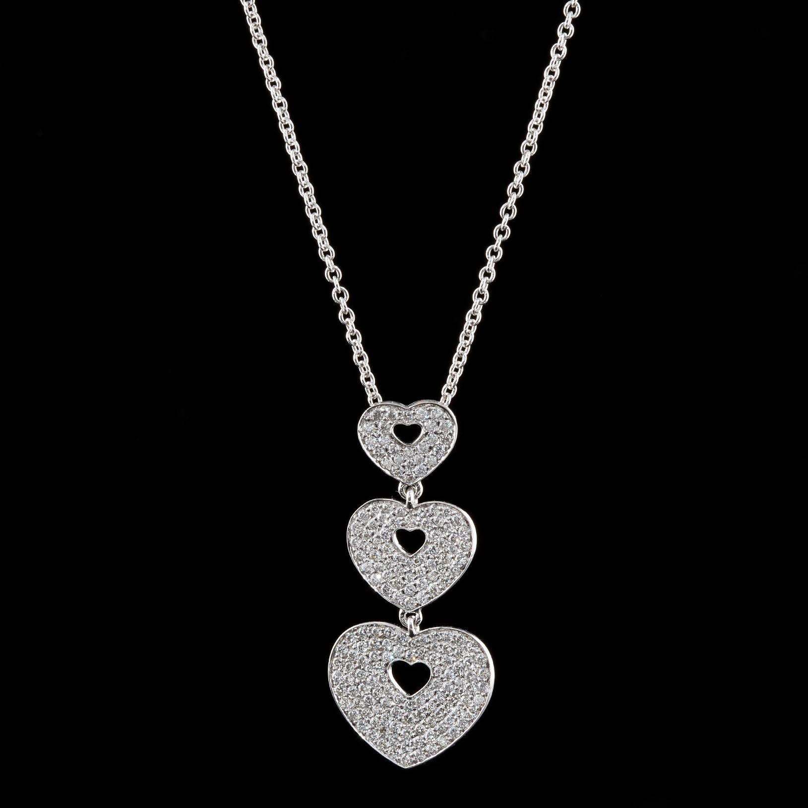 Poiray 18Kt White Gold Diamond Three Heart Necklace Features 0.91 Total Carat Weight of Round Brilliant Cut Diamonds. The 33mm long pendant measuring 9mm to 15mm wide is suspended from a 15 inch chain. This piece weighs 6.5 grams.