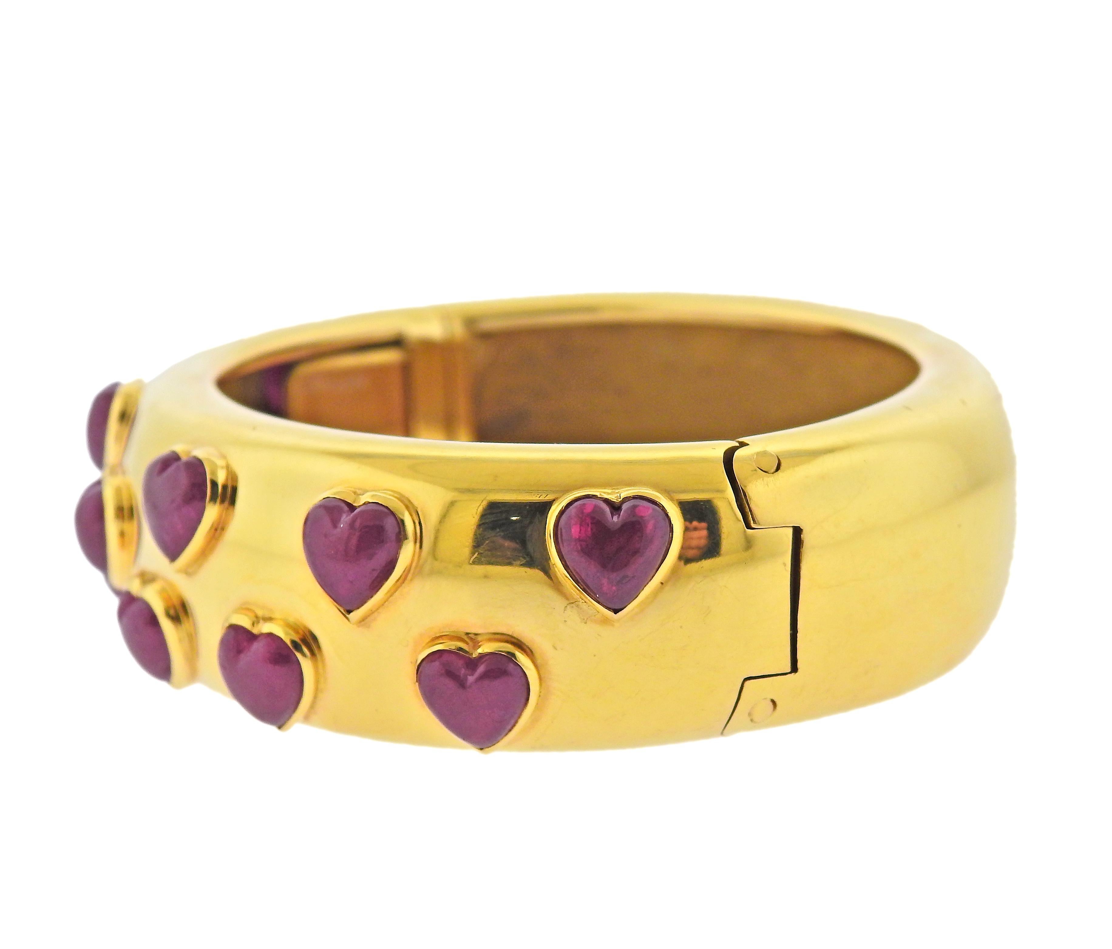 Poiray France 18k yellow gold bangle bracelet with heart shaped ruby cabochons. Bracelet will fit approx. 7