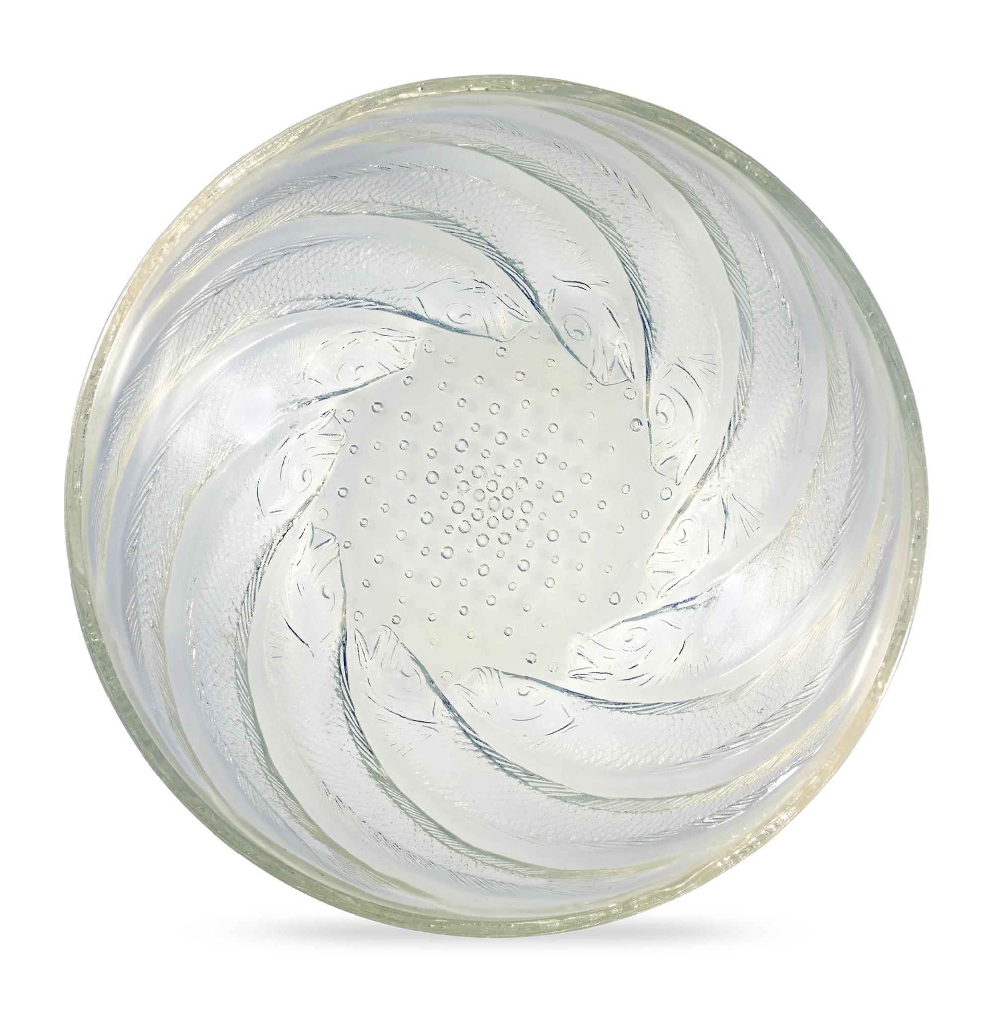Designed by René Lalique in 1921, this Poissons pattern bowl showcases a swirling motif composed of lithe swimming fish. The vessel highlights the master's love of the bold forms and the natural motifs that typified his output. Composed of
