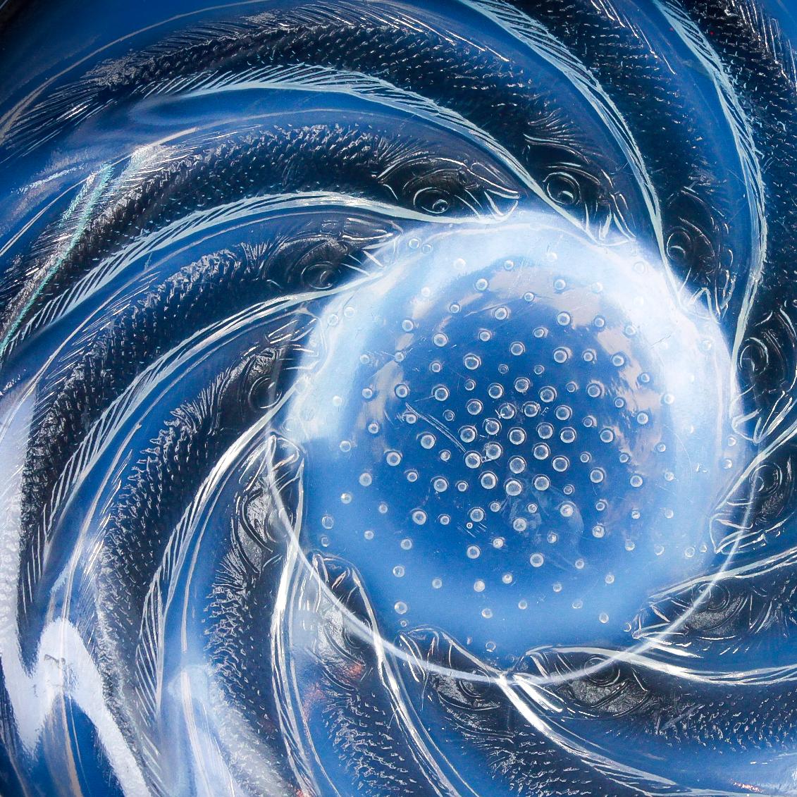 Poissons No.1, an Art Deco opalescent and frosted glass plate by René Lalique. Swimming fish in swirls surrounding a glass bowl.

Literature: Marcilhac, R Lalique Catalogue Raisonné de L’Œuvre de Verre p.707.

Scratches, wear and chip consistent