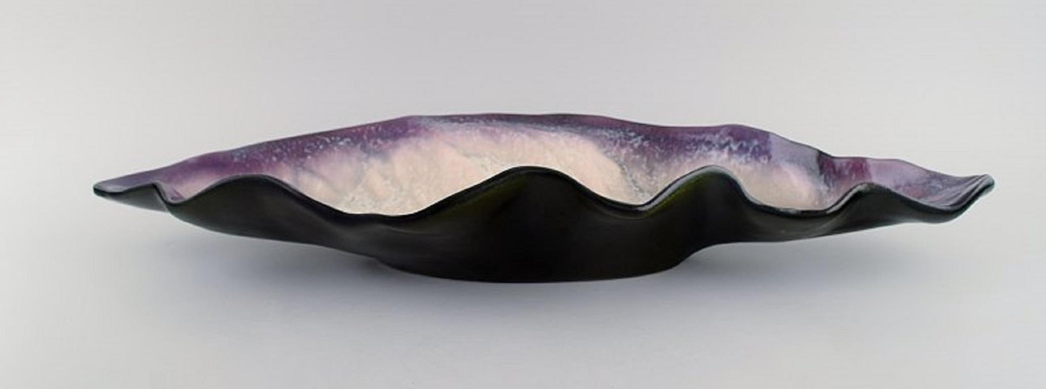 Pol Chambost (1906-1983), France. Colossal bowl in glazed stoneware shaped like a leaf.
Beautiful glaze in purple and light pink shades. 1940s.
Measures: 60.5 x 20 cm.
Height: 9 cm.
In excellent condition.
Signed.