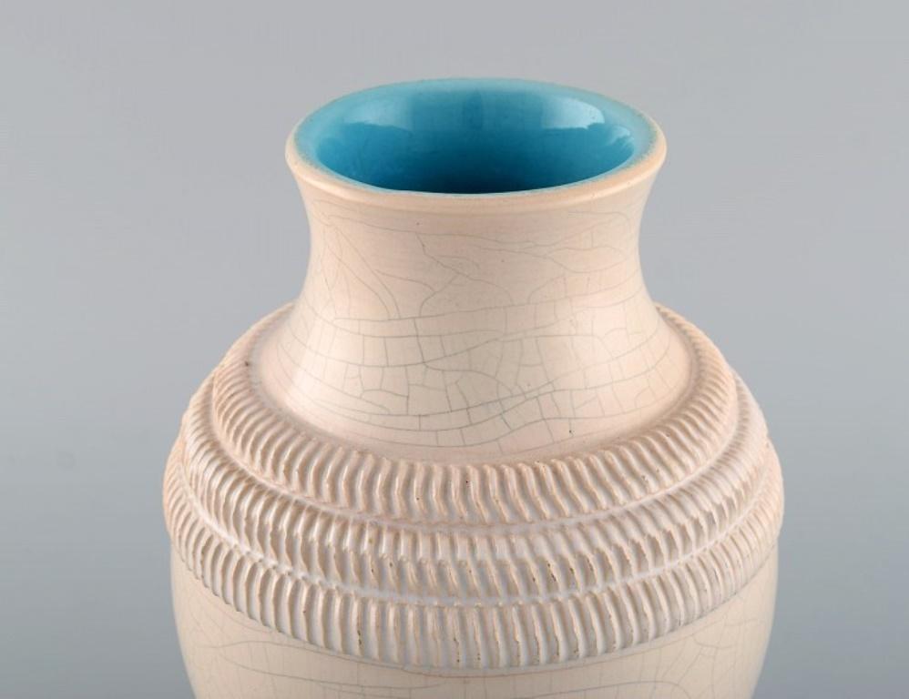 Pol Chambost (1906-1983), éminent artiste céramiste français.
Vase en céramique émaillée. Magnifique glaçure craquelée dans des tons de sable. 
1930's.
Dimensions : 21 x 15,5 cm : 21 x 15,5 cm.
En très bon état.
Estampillé.