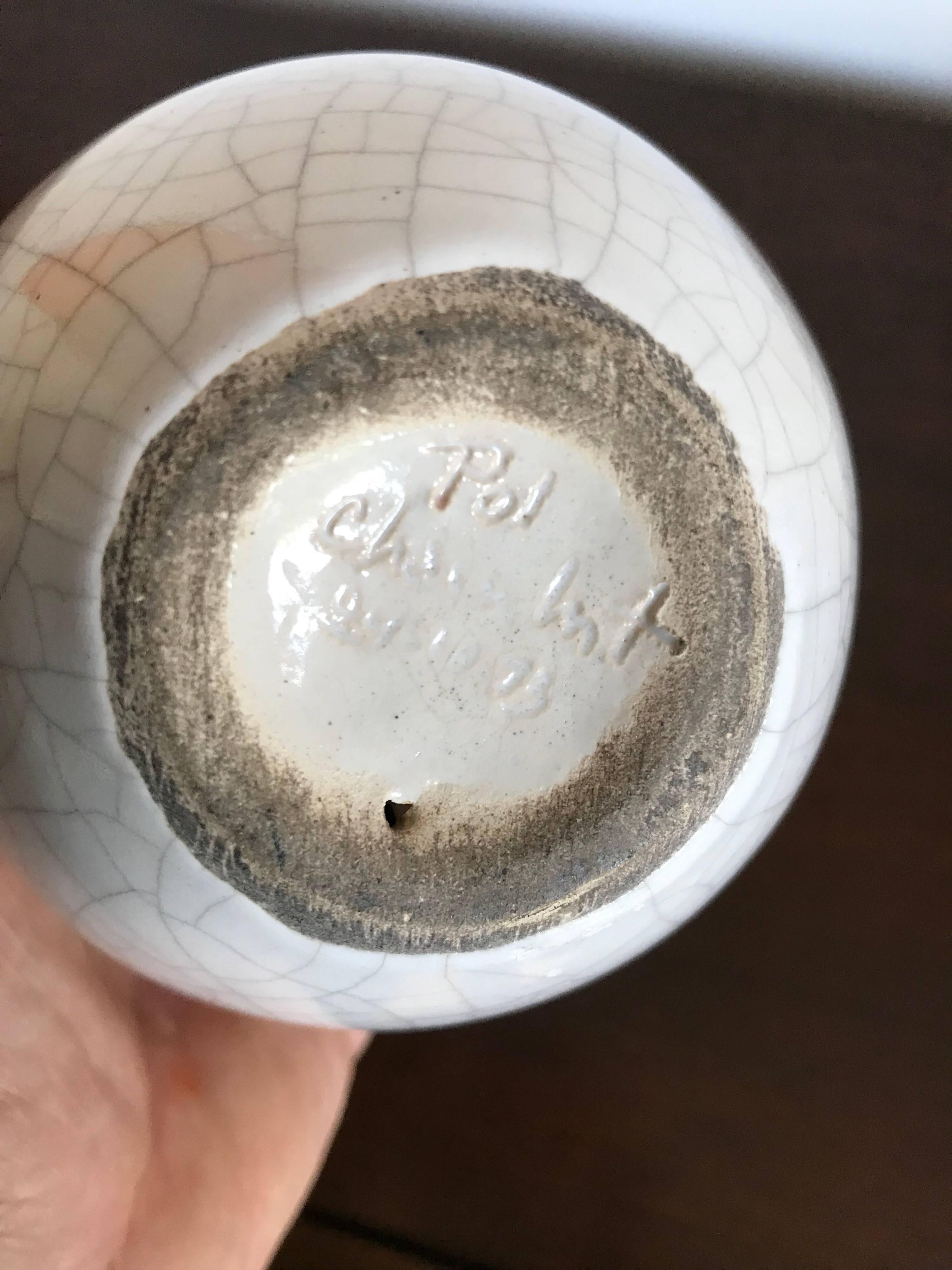A nice decorative art object.
Made of clay with a wonderful white crackle glaze.
No cracks or chips, but it has a few flea-bite nicks, no major damage.
Signed on the bottom 