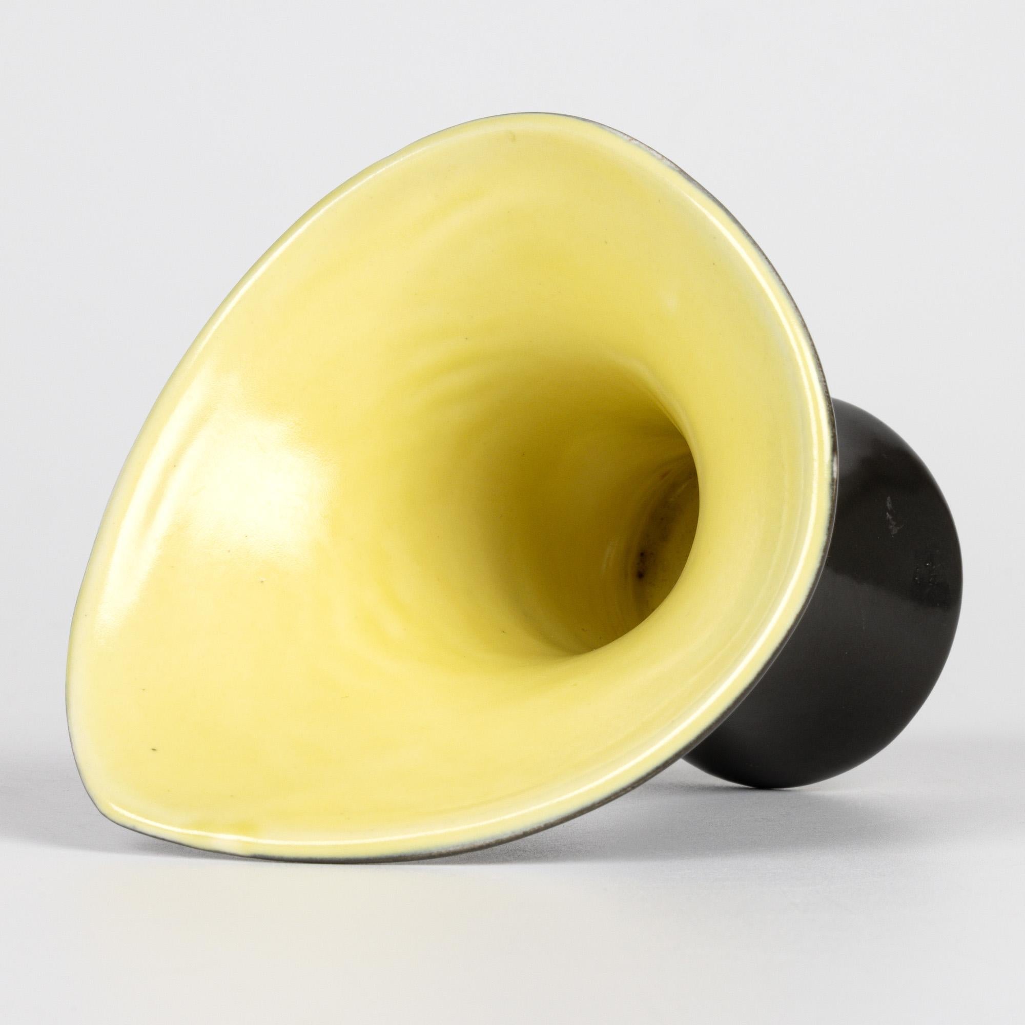 Impresionante jarrón de cerámica artística francesa de mediados de siglo, de característico esmalte negro y amarillo, atribuido al célebre artista francés Pol Chambost. Esta maravillosa vasija de barro de forma libre y pequeño tamaño, una de las