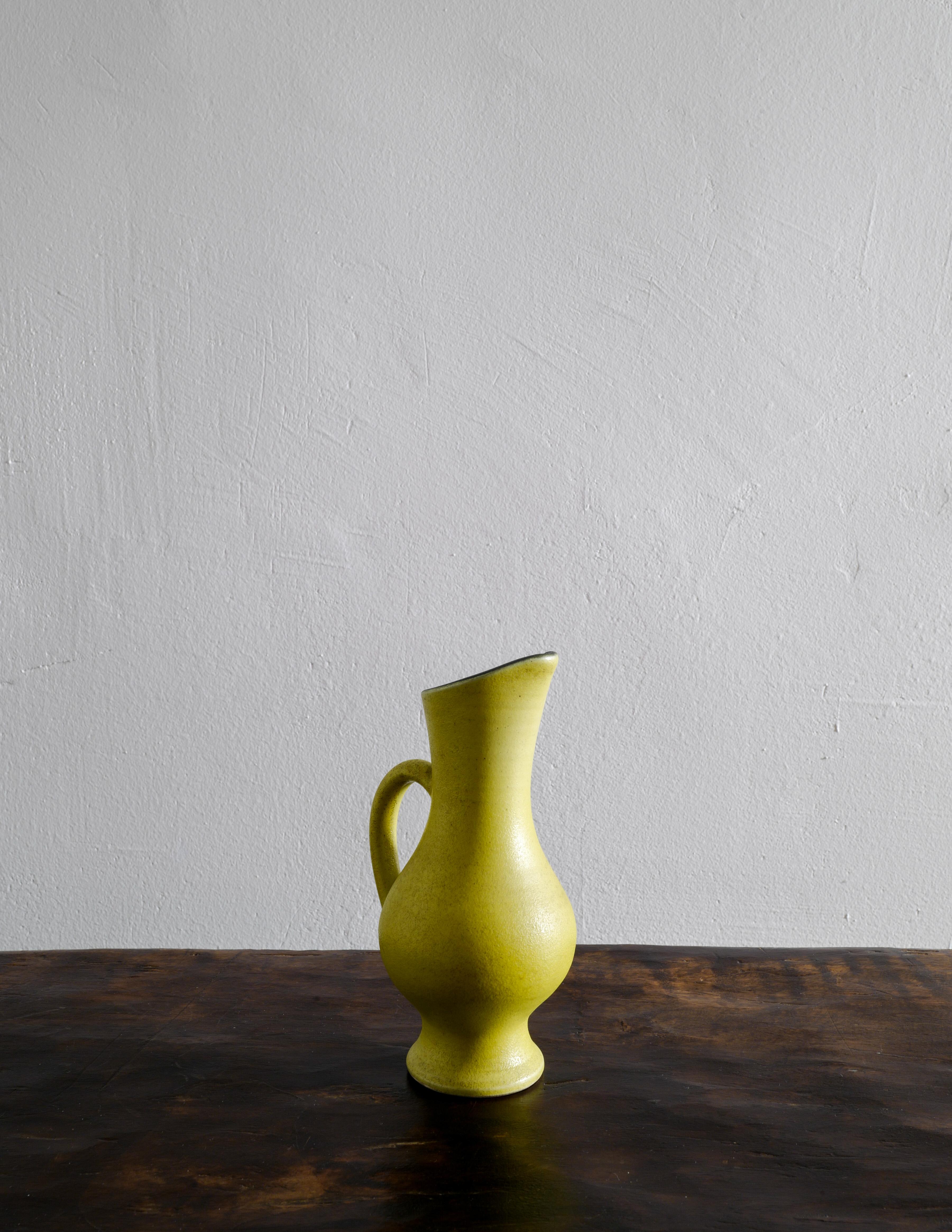 Rare pitcher / jug designed and made by the French artist and ceramicist Pol Chambost in a beautiful and warm yellow glaze with a contrasting black inside. In good vintage and original condition with small signs from age and use. Goes well with