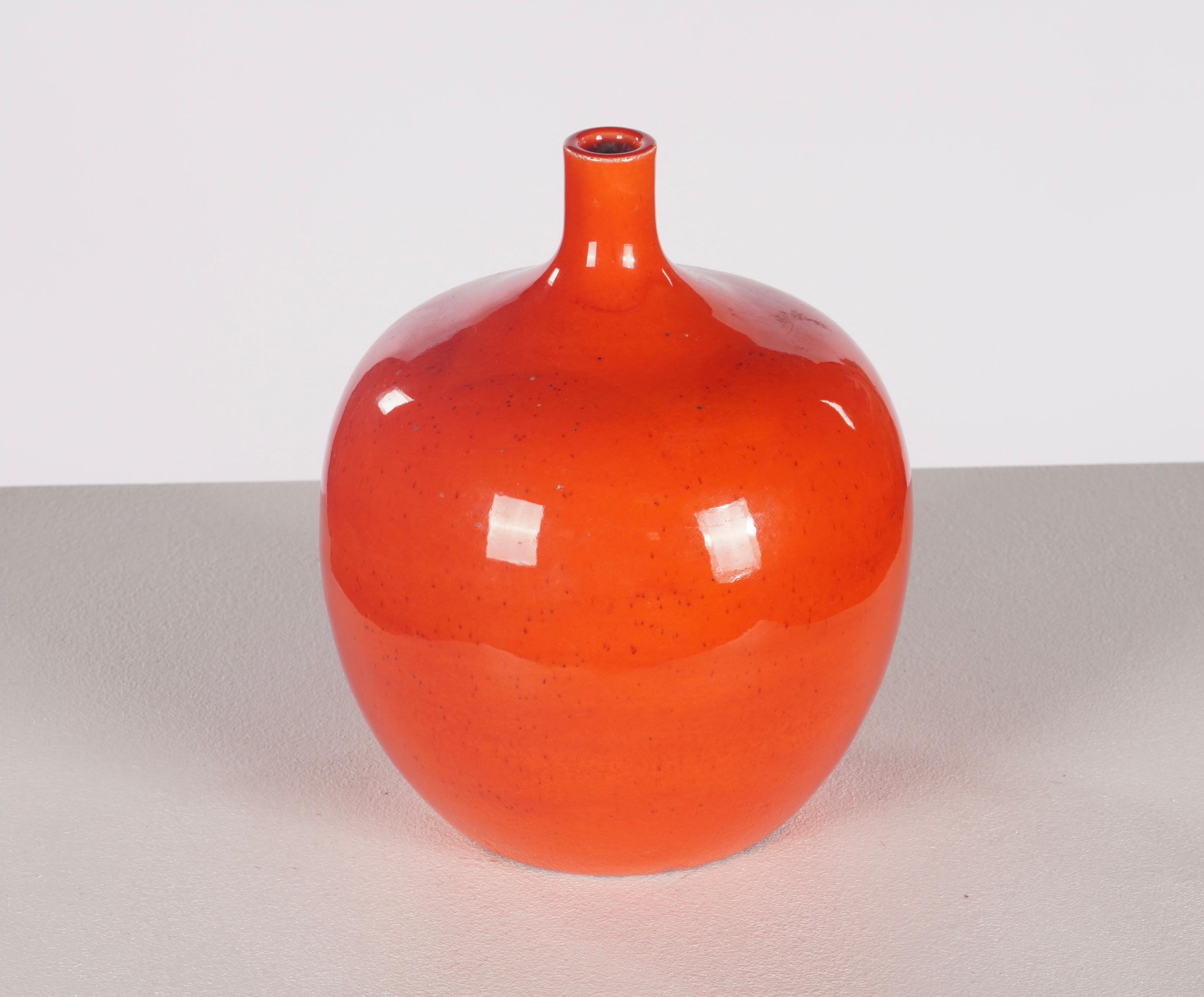 Vaso a bulbo di Polia Pillin della California del Sud con un vibrante smalto rosso, un pezzo insolito in quanto privo delle sue immagini ornamentali; l'artista lavorava con il marito William nello studio di casa, lui creava le forme e gli smalti e