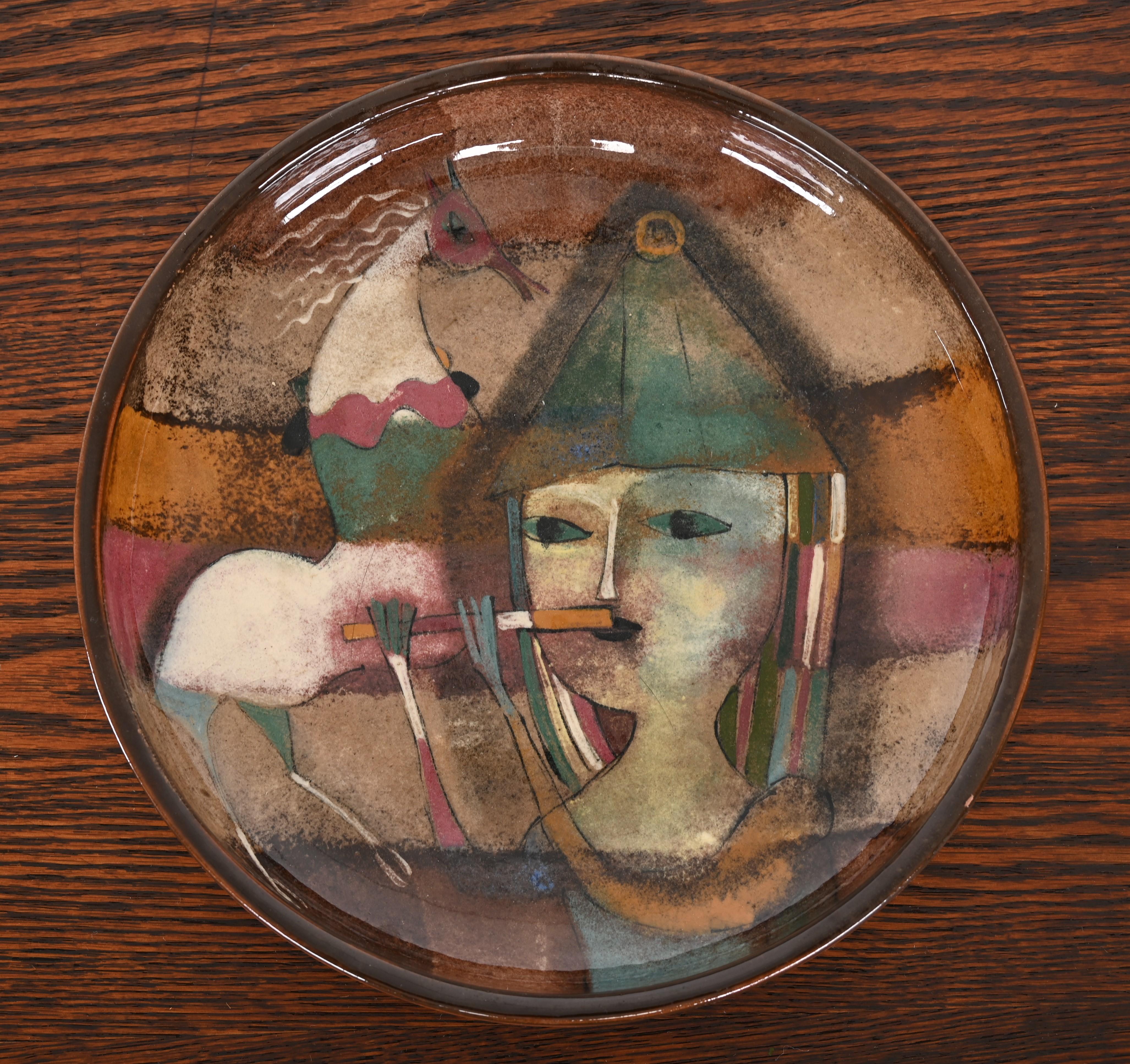 A large ceramic dish, plate or bowl decorated with a woman playing the flute with a horse in the background. Handmade by the artist Polia Pillin of Los Angeles, California. Signed 