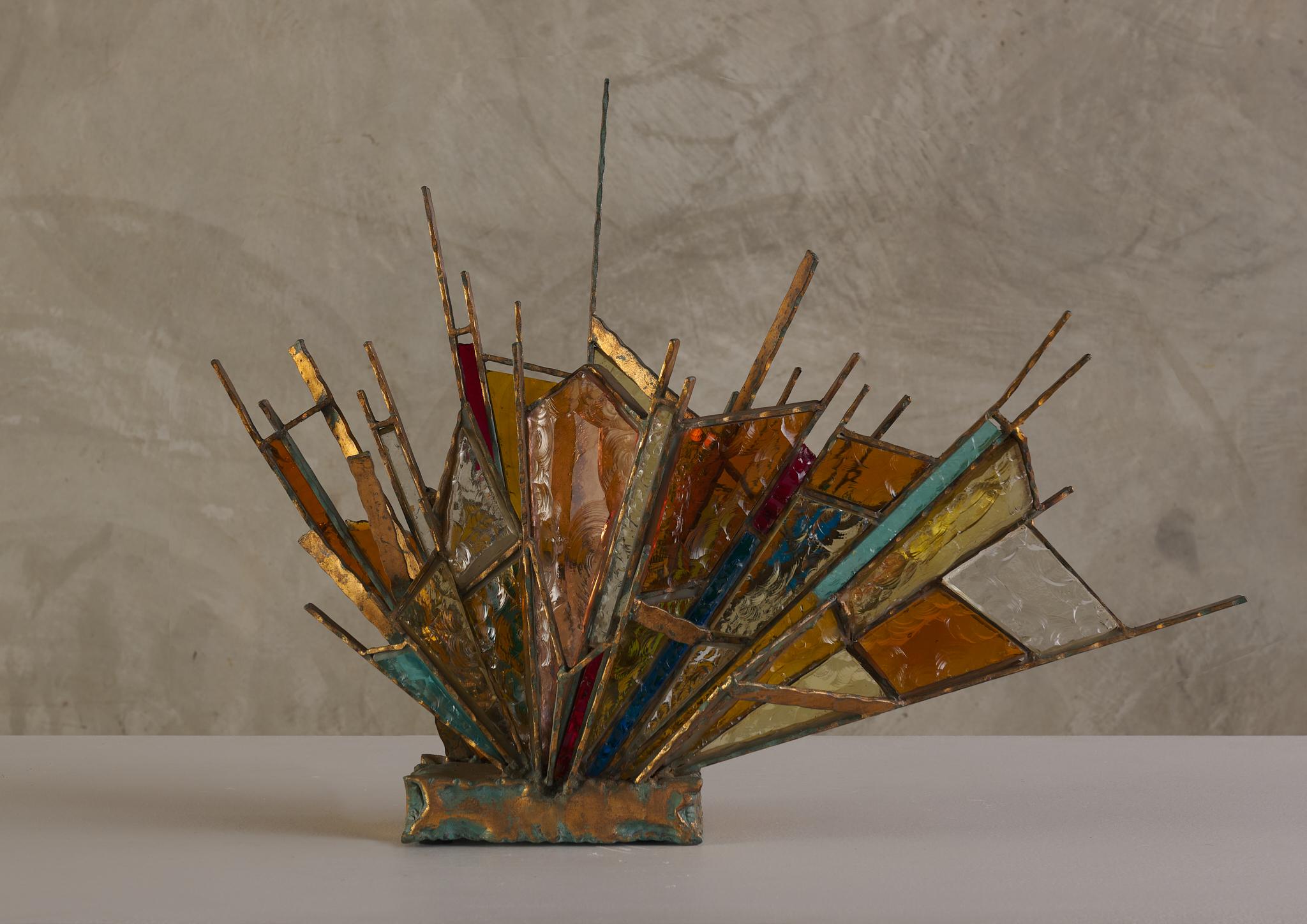 The amber glass tones from this Brutalist lamp gives off a warm subtle light contrast to the design.