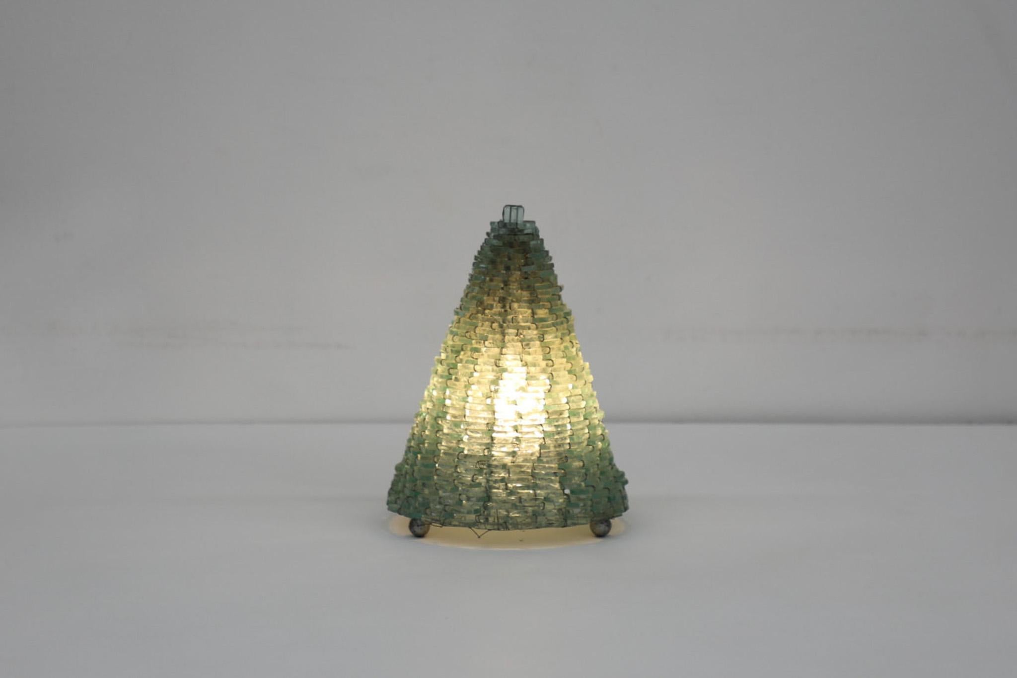 Poliarte style woven glass and wire modernist cone table lamp. In original condition with visible wear consistent with its age and use. Shown with slightly smaller matching pyramid lamp, listed separately. Max 220v 25w E14 bulb.