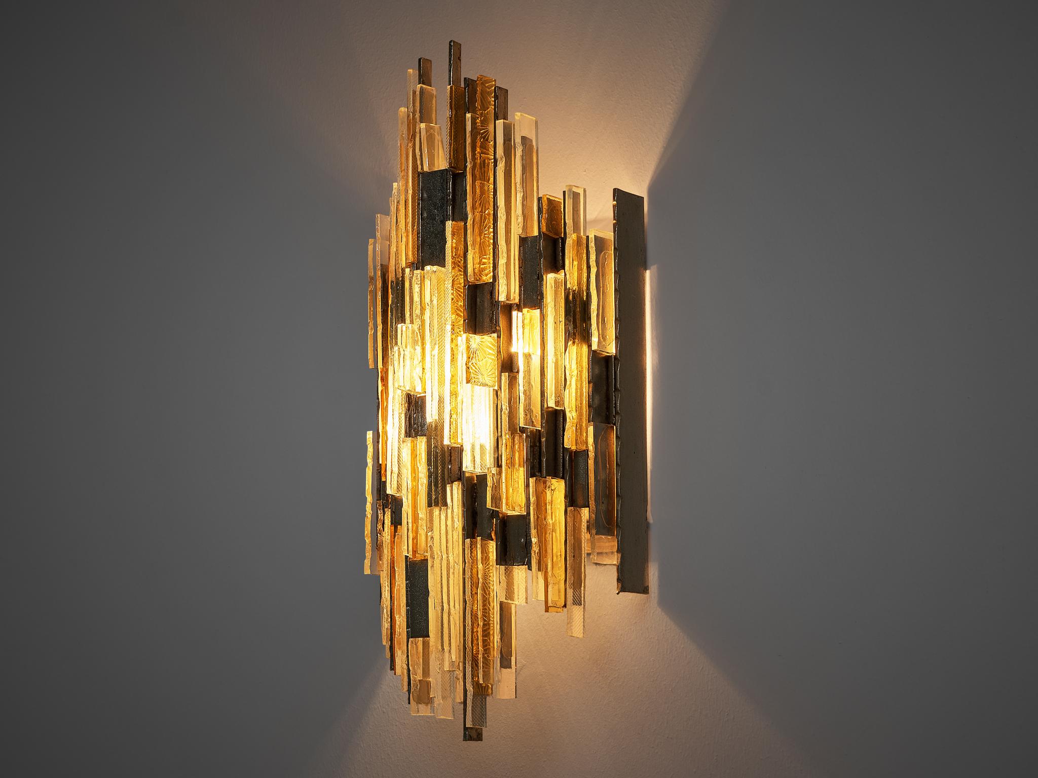 Poliarte, wall light, brass, glass, Italy, 1960s

Very sculptural wall light created by Poliarte in the 1960s. The transparant and amber chiselled glass create a unique design and are structured into different rows. They are contrasted by pieces