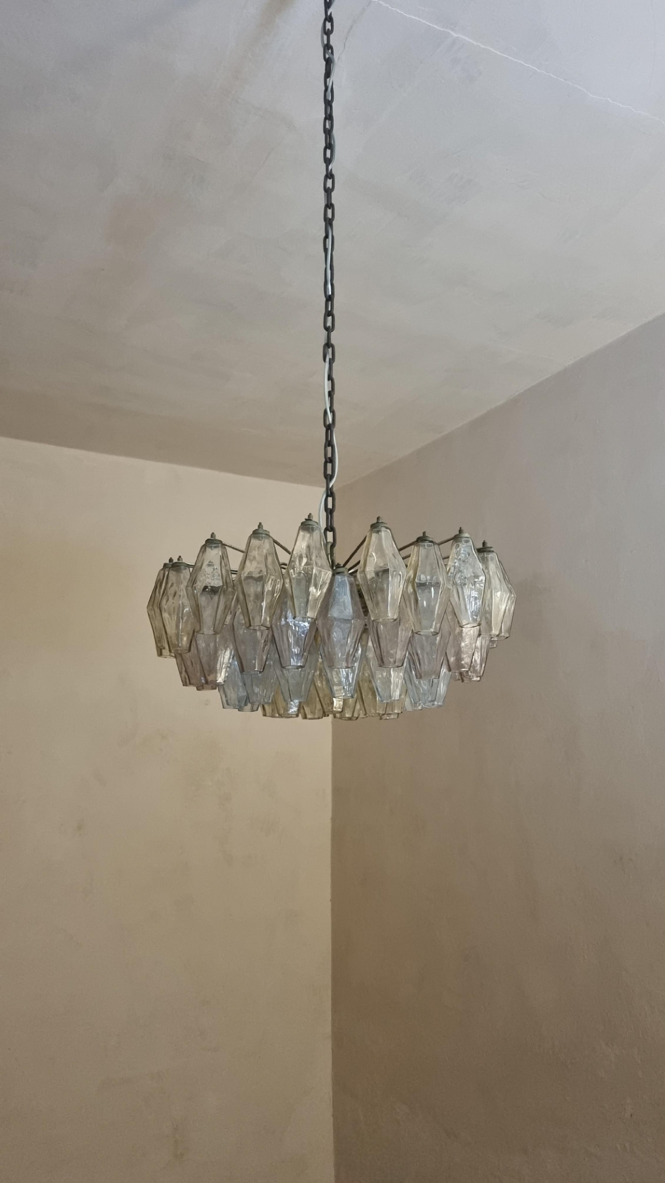 Lampadario a soffitto Poliedri disegnato da Carlo Scarpa nel 1958 per vetreria Venini. 
Struttura in ottone nichelato , elementi in vetro soffiato trasparente nei toni del giallo, del rosa e del blu, composta da 67 poliedri, eccellenti condizioni,