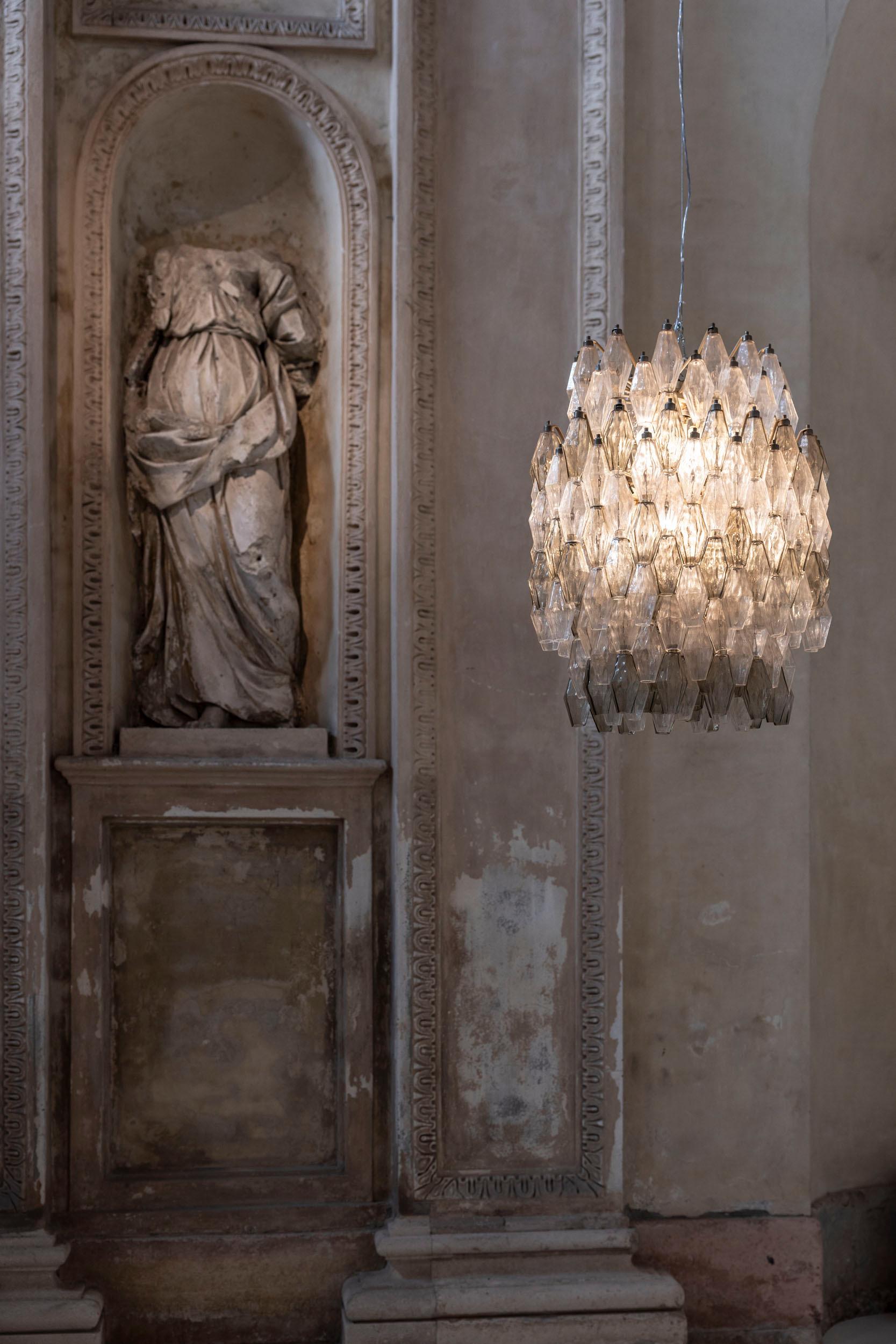 Elegant poliedri chandelier attributed to Carlo Scarpa for Venini, featuring hand-blown Murano glass with a mix of transparent and soft grey tones. 
The metal structure supports a high number of polyhedrons, enhancing its  distinctive elegance.