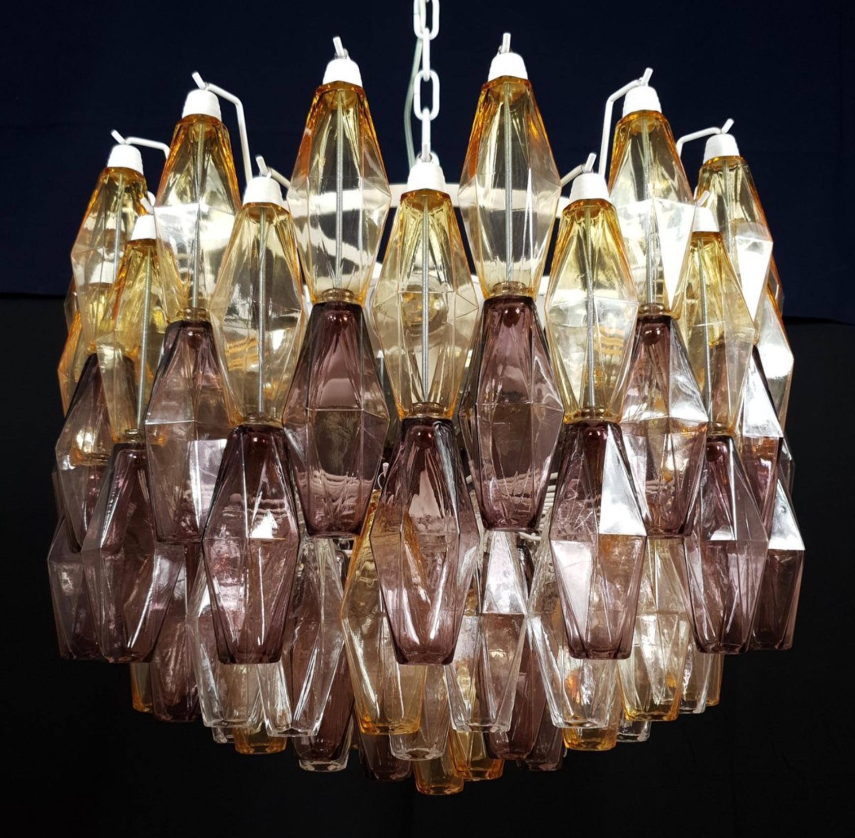 Lustre moderne italien avec des verres de Murano en forme de polyèdres d'ambre et d'améthyste, montés sur une monture en métal blanc / Made in Italy by Fabio LTD
Diamètre : 20 pouces / Hauteur : 16 pouces plus la chaîne et le baldaquin
5 lampes /