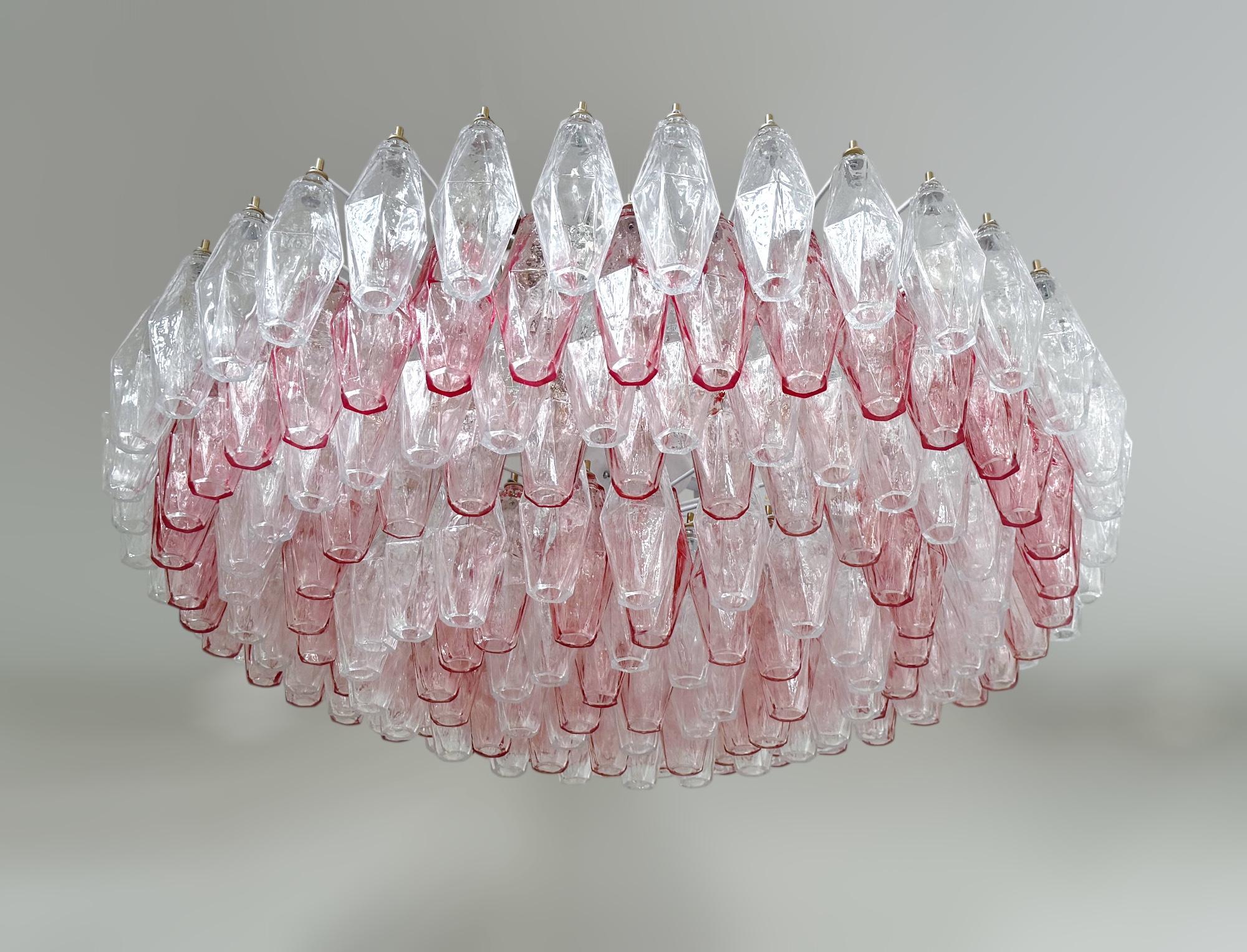 Lampadario moderno italiano con vetro di Murano chiaro e rosa a forma di poliedro, montato su una struttura in metallo smaltato bianco, nello stile di Venini e Carlo Scarpa / Prodotto in Italia da FABIO LTD
Diametro: 36 pollici / Altezza: 10 pollici