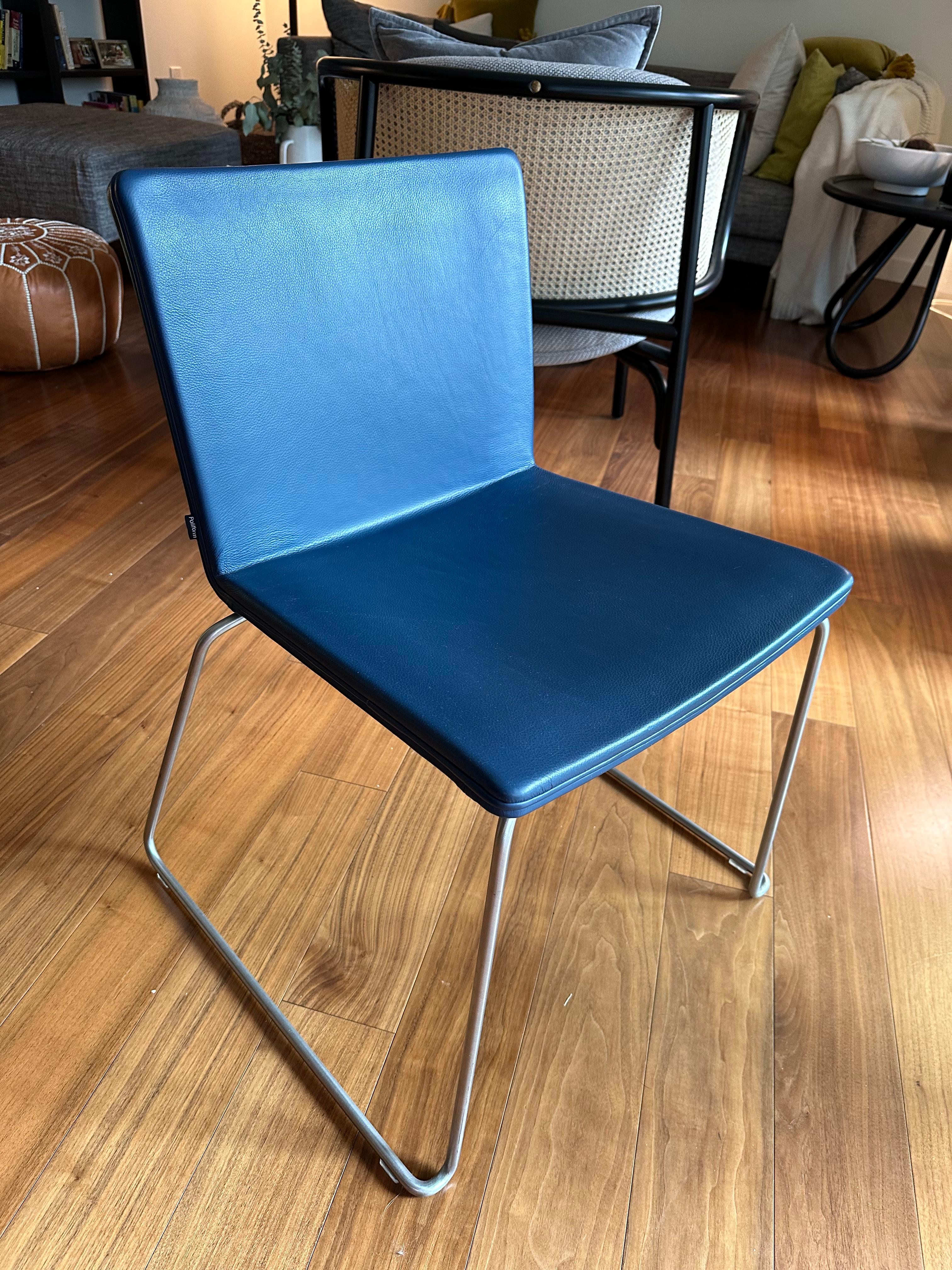 Originally designed by Mario Mazzer for Poliform in 2003, the Nex dining chair is the epitome of sleek and modern design. Featuring a chromed metal frame with sled base, the seat is molded for comfort and upholstered blue leather. This chair would