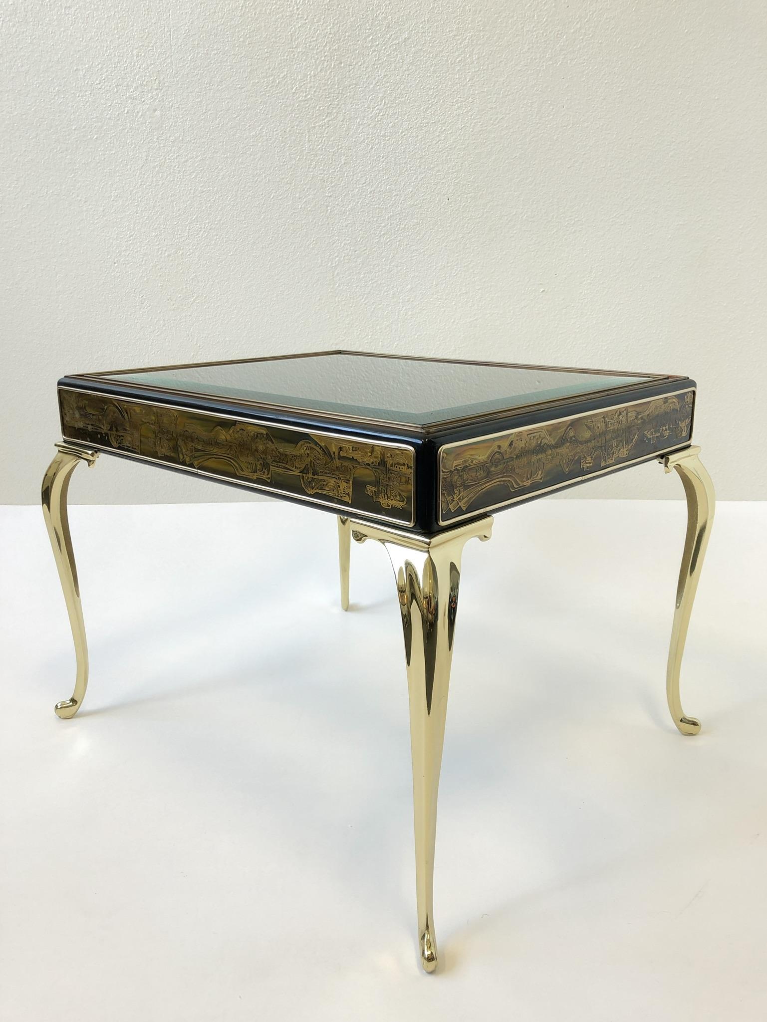 A glamorous polished brass and black lacquer side table design by Bernhard Rohne for Mastercraft in the 1970s. The table is constructed of solid polish brass legs the frame is wood black lacquered with acid edje design attached on the sides and the