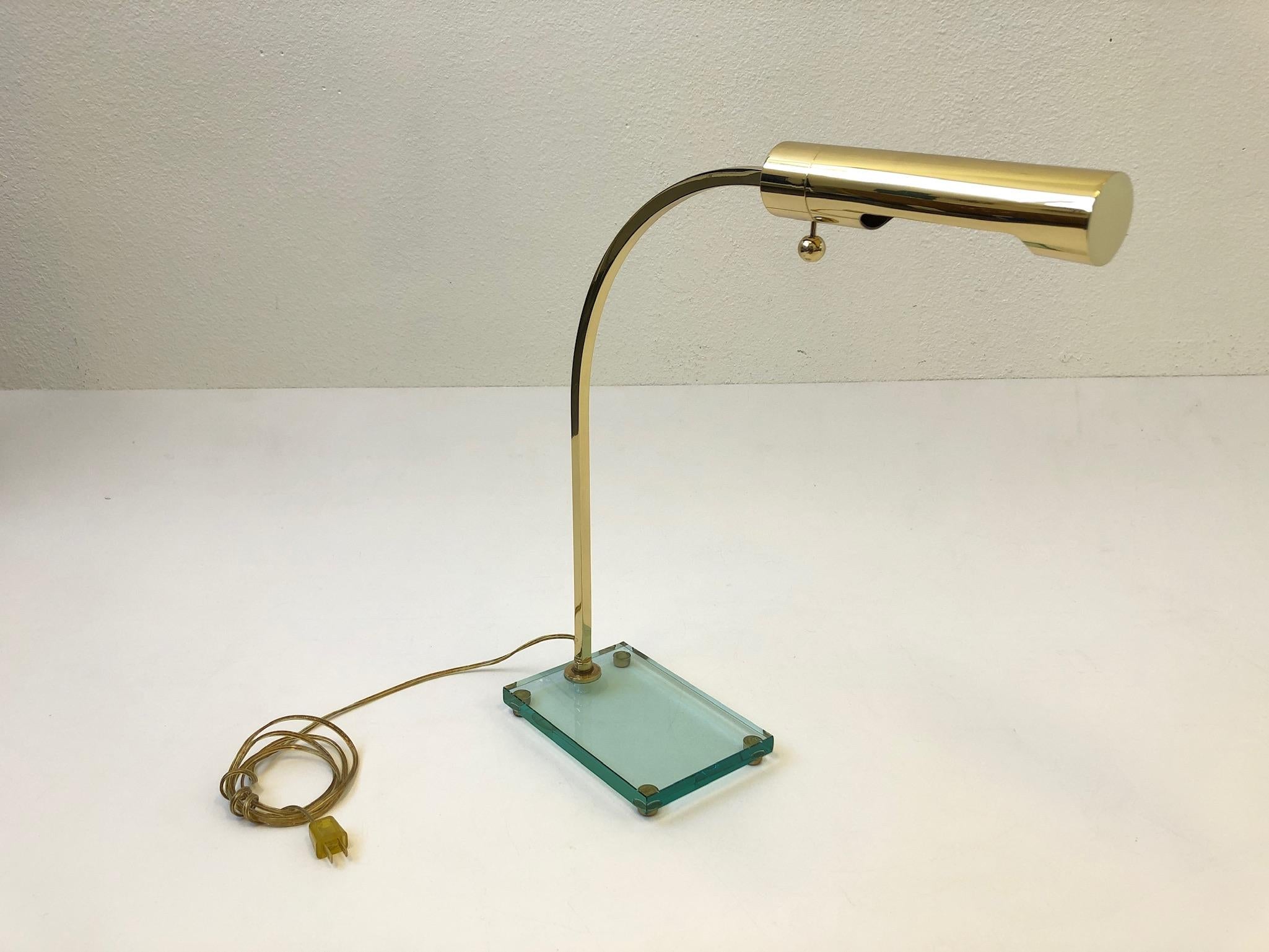 Eine glamouröse Schreibtischlampe aus poliertem Messing mit Glassockel aus den 1970er Jahren im Stil von Fontana Arte. Die Leuchte ist neu verkabelt worden.
Abmessungen: 20