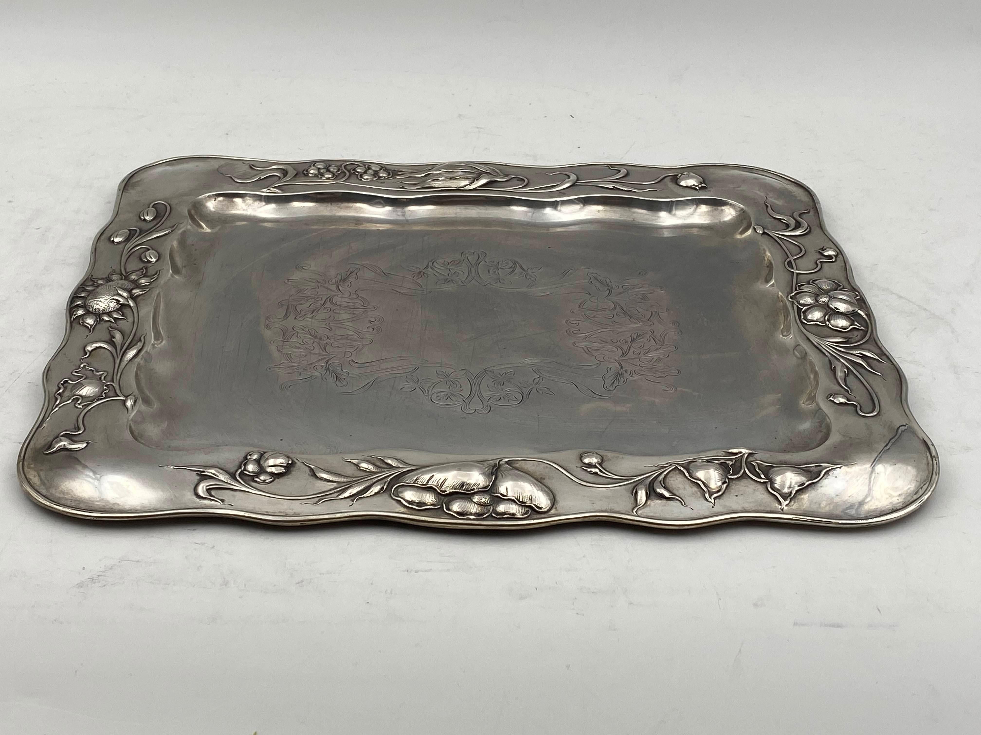 800 Continental silver tray platter by a Cracow-based silversmith made in the early 20th century in Art Nouveau style with exquisite raised floral patterns around the rim as well as engraved stylized flora at the heart of the tray. Measuring 16 1/2”