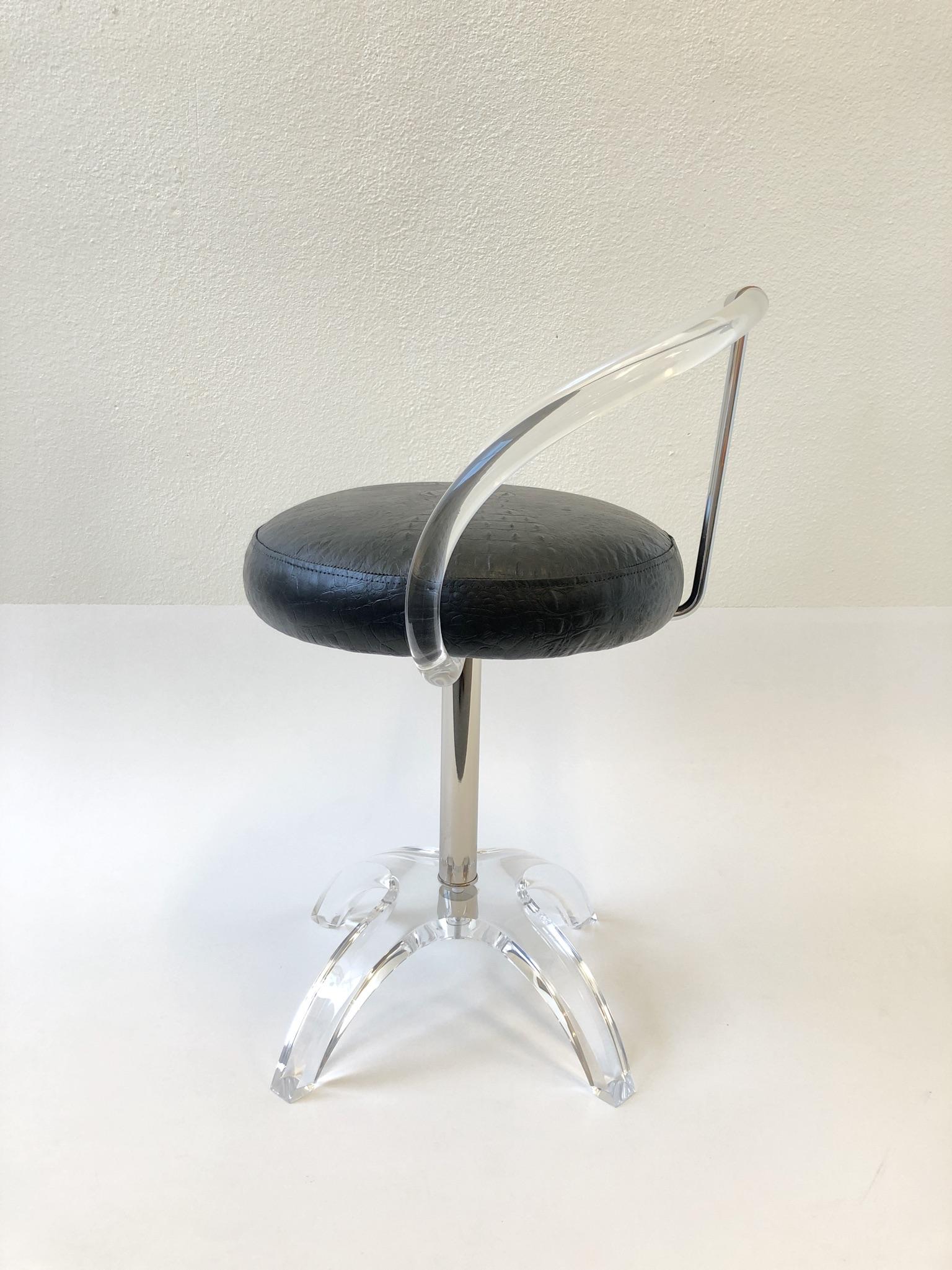 A glamorous polish nickel and clear acrylic swivel vanity stool. Design by Charles Hollis Jones in 1965 ( commission by Lucille Ball ). 
The stool has been newly restored. The seat is covered with a black distressed faux crocodile embossed leather.