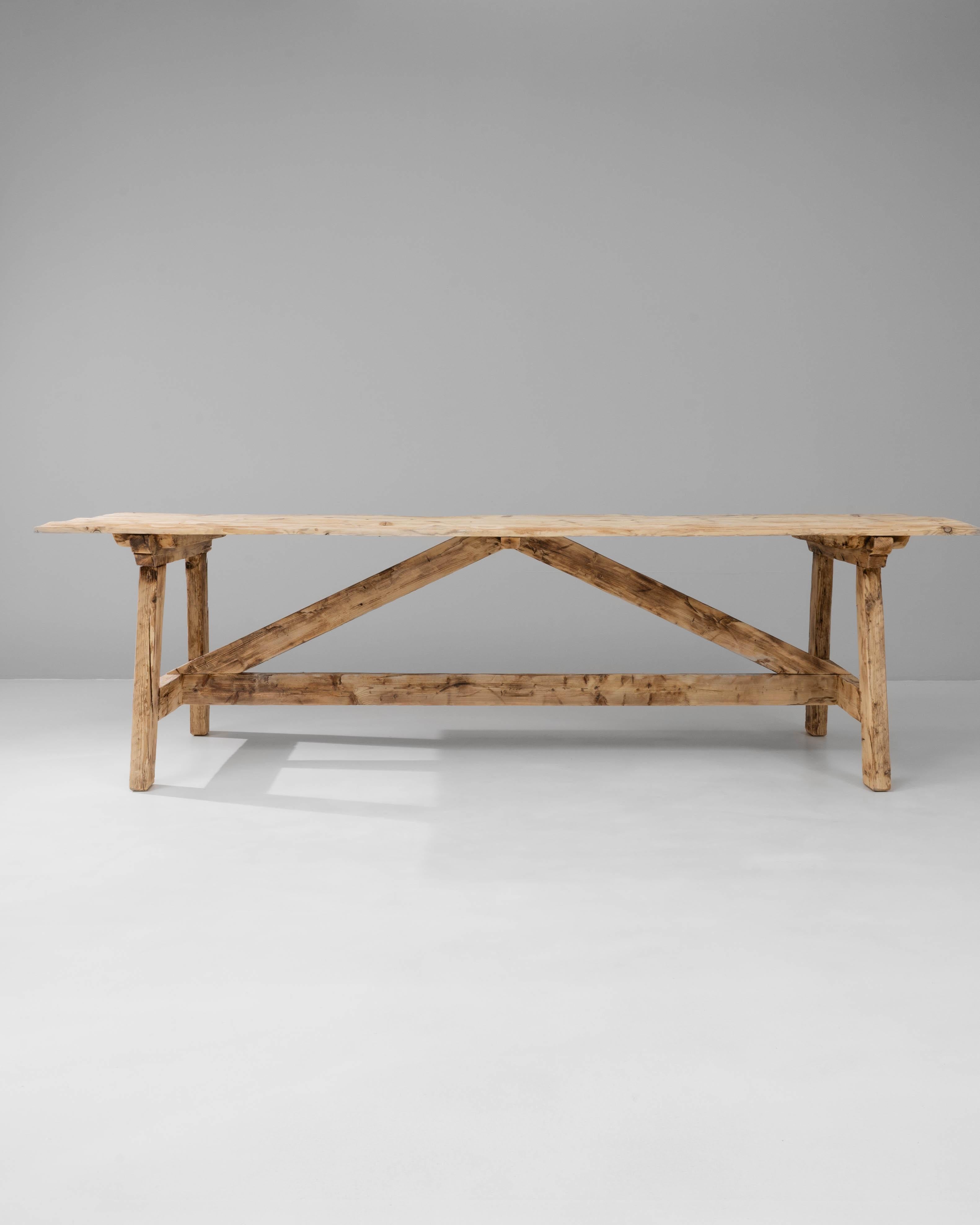 Esta mesa de comedor de caballete de pino polaco presenta un diseño atrevido a la par que rústico, fabricado en pino macizo con un acabado naturalmente desgastado que resalta su carácter auténtico. La larga encimera rectangular descansa sobre