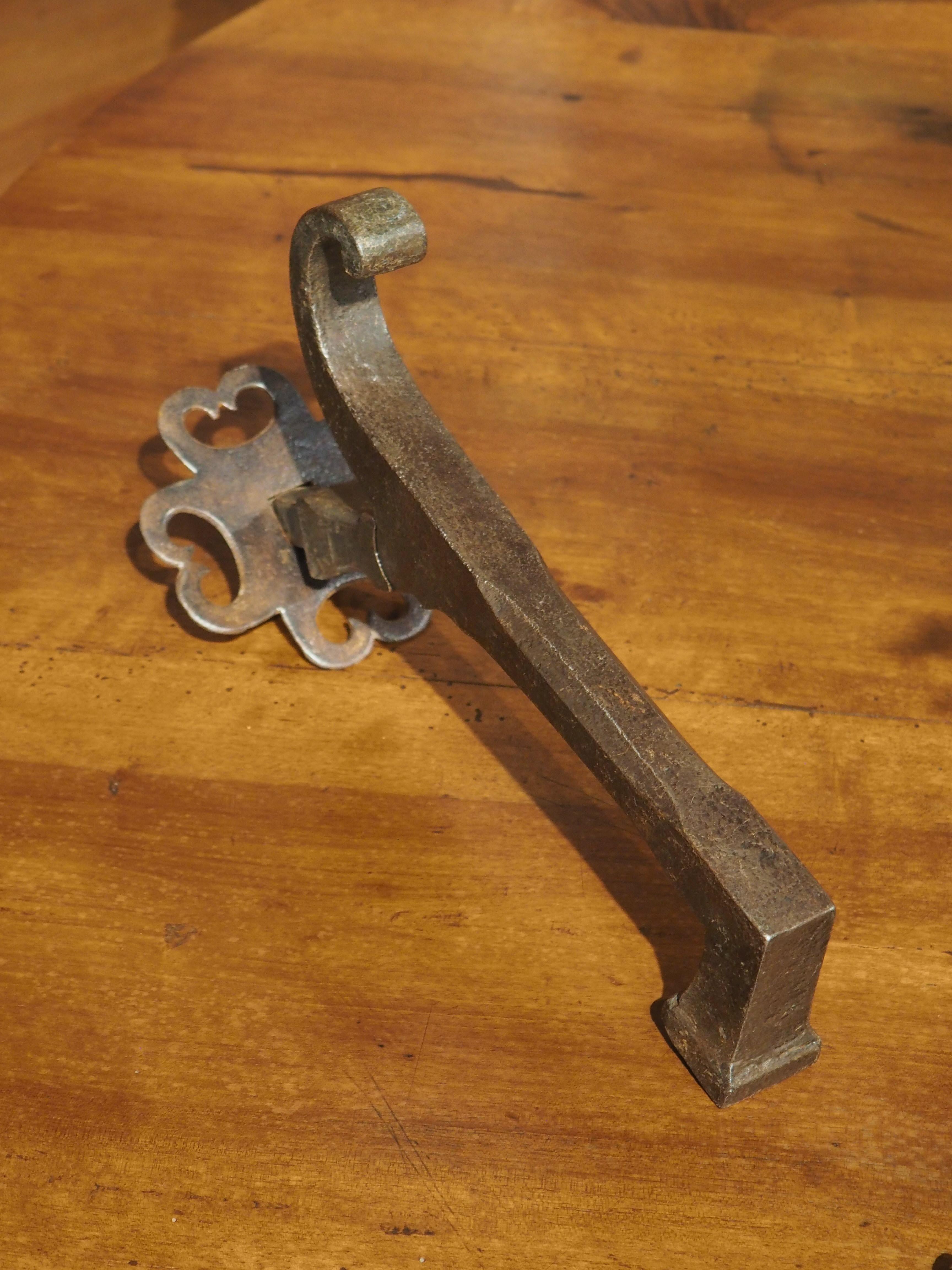Wrought iron is a very durable, yet malleable material that has been used for centuries to make highly worked items. This polished wrought iron French door knocker from the 1700s has been shaped as an “L” form with a scrolled tip. A horizontal bolt