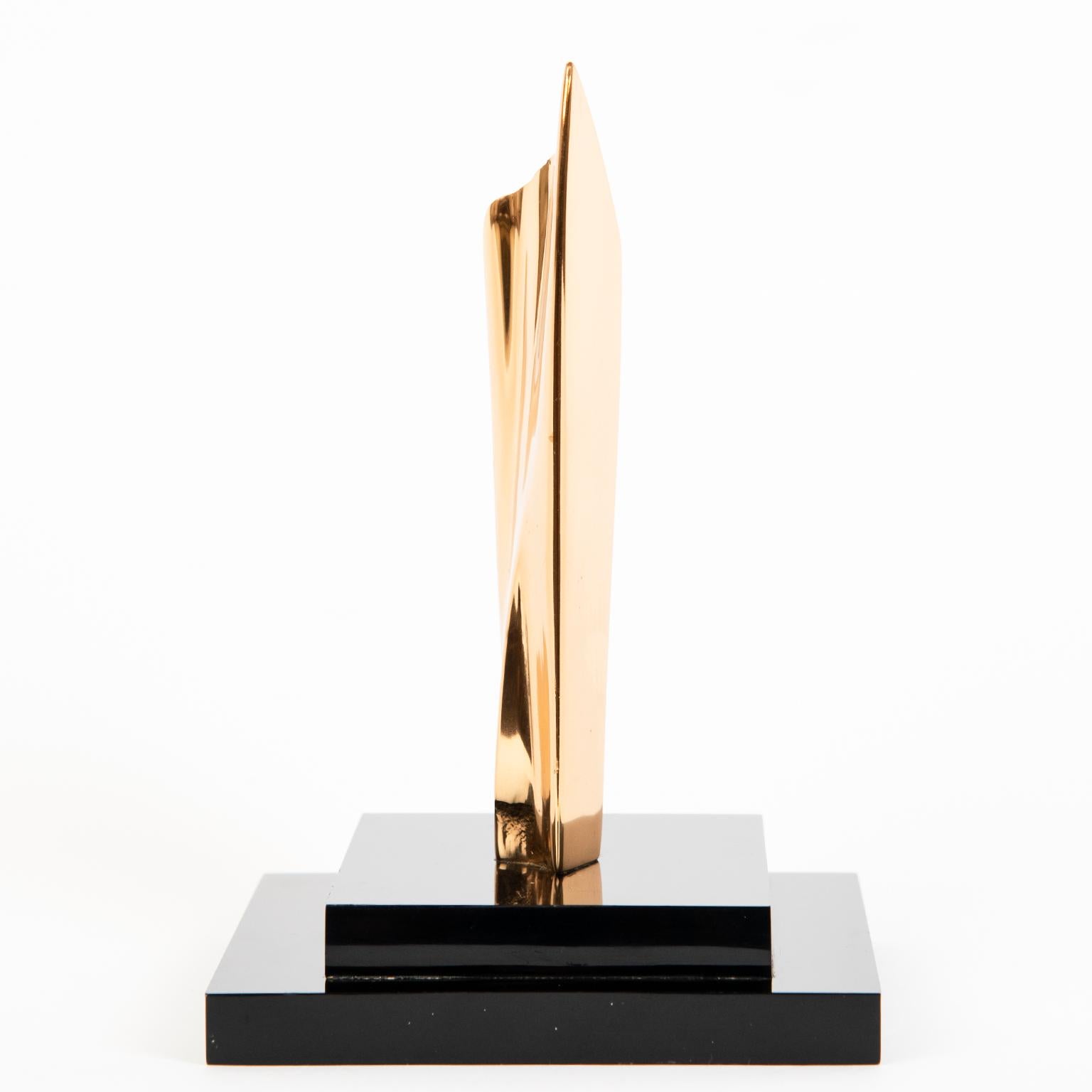 A diminutive polished abstract gilt bronze on black acrylic stand by Canadian May Marx, etched signature at the base and labeled with sticker under 