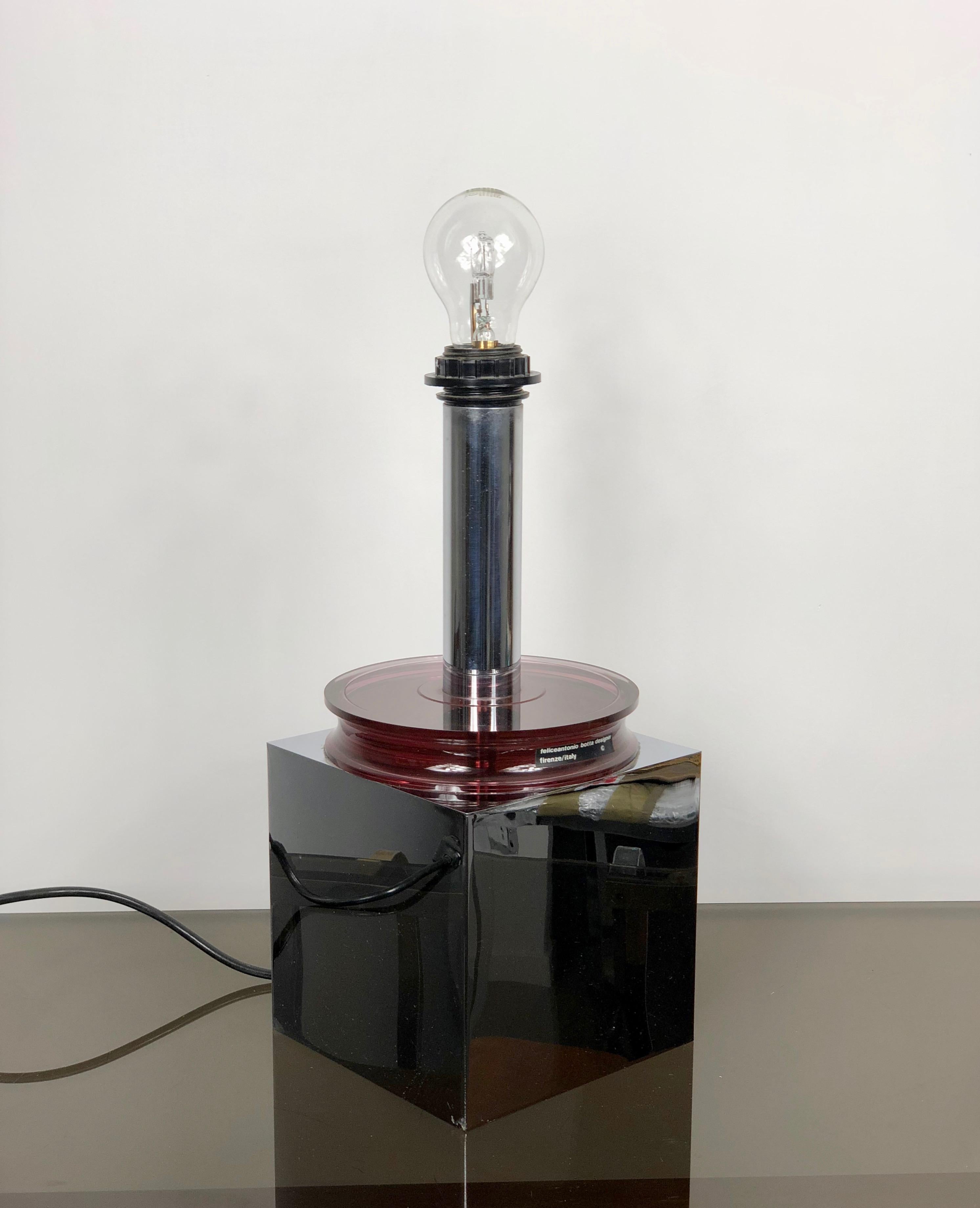 Table lamp by the Italian Felice Antonio Botta (there is still the original label) resting on a polished aluminum base and a dark red Lucite circle, Italy, circa 1970.
