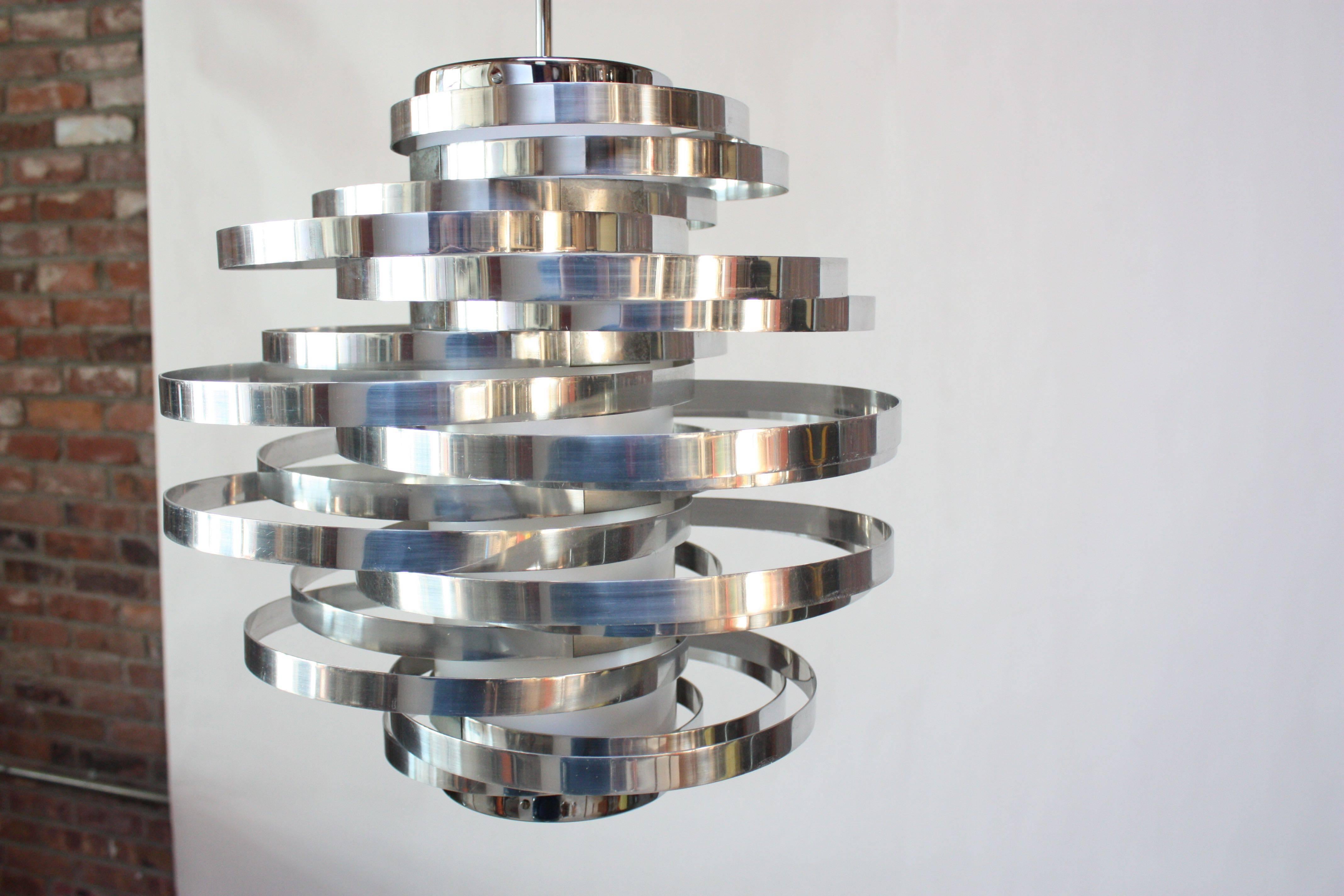 Gaetano Sciolari 1970s 'Cyclone' ceiling fixture composed of polished aluminum rings mounted to a center cylindrical shade in white acrylic with chromed-metal accents, canopy, and hardware. Single socket.
Excellent, vintage condition with only minor