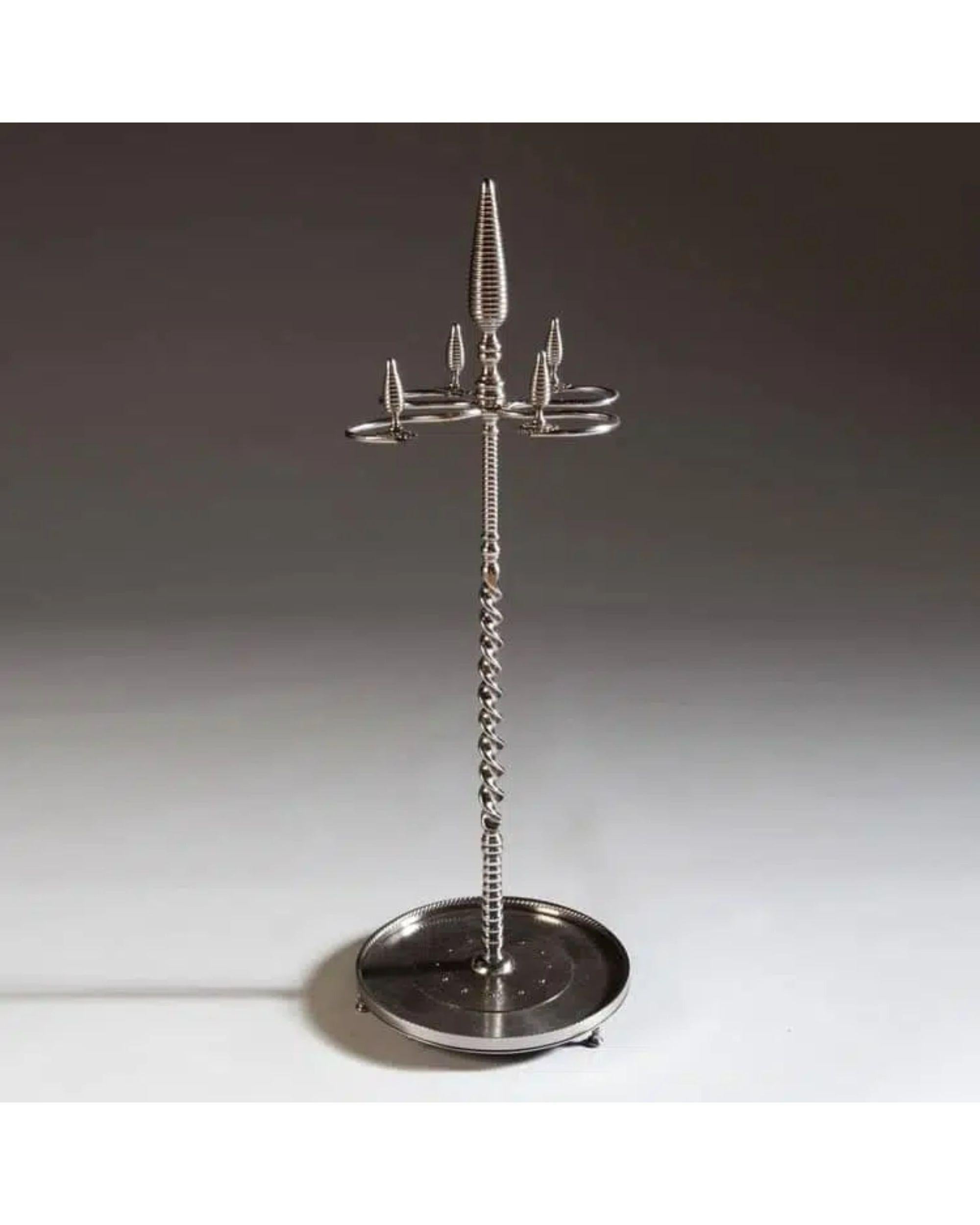 A highly unusual late Georgian polished and cut steel fire iron stand.

Having a barley sugar twist stem and spaces for irons terminating in boldly modeled stylised acorn finials. Each element is finely finished and enhance with bright cut beads and