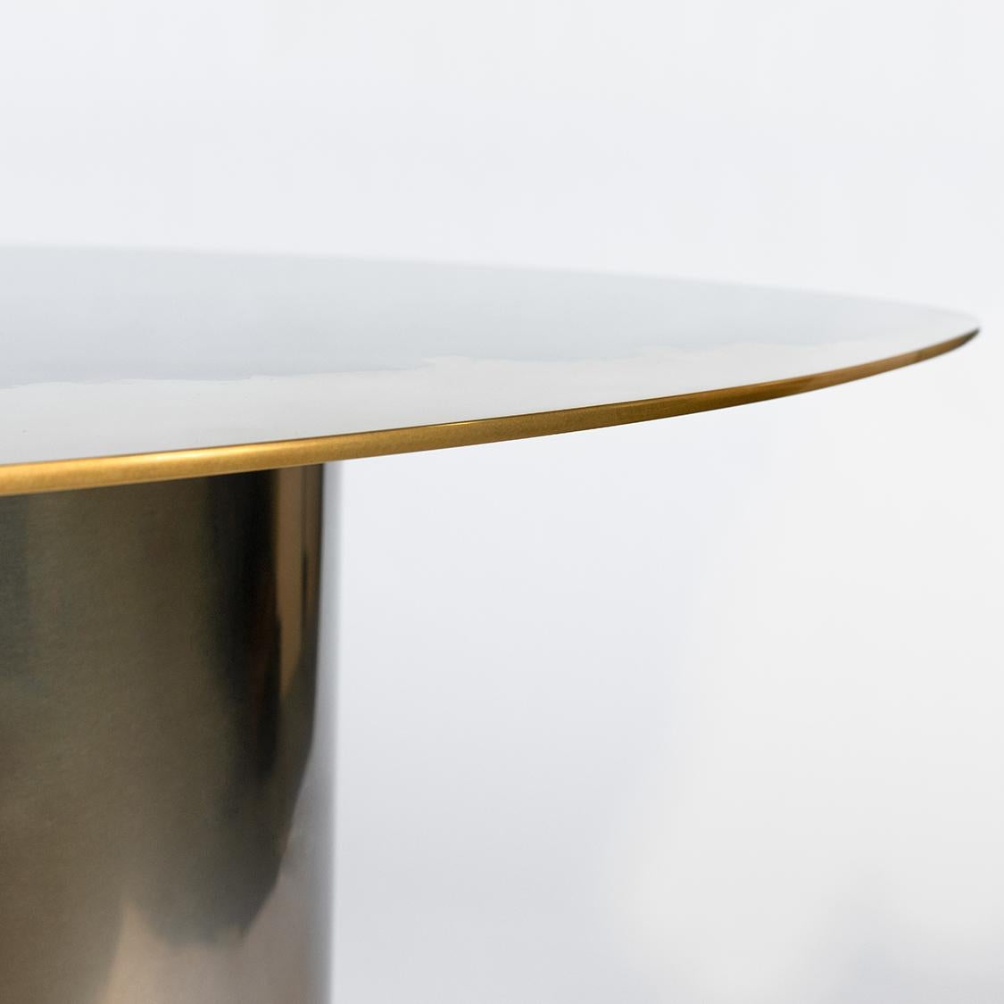Table d'appoint faisant partie de la collection Transition, présentant un plateau unique et artistique poli miroir, fabriqué en laiton et en acier inoxydable sur une base tubulaire. Mesures : H 22