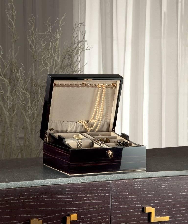 Boîte à bijoux en ébène poli. Verrouillable par clé, avec la barre de collier sur le dessus et un plateau amovible à l'intérieur. Toute la quincaillerie est plaquée or rose 24 carats.